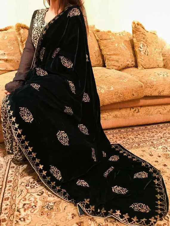 A elegantly draped velvet shawl showcasing floral patterns and block-printed border on all four sides in golden thread accents.