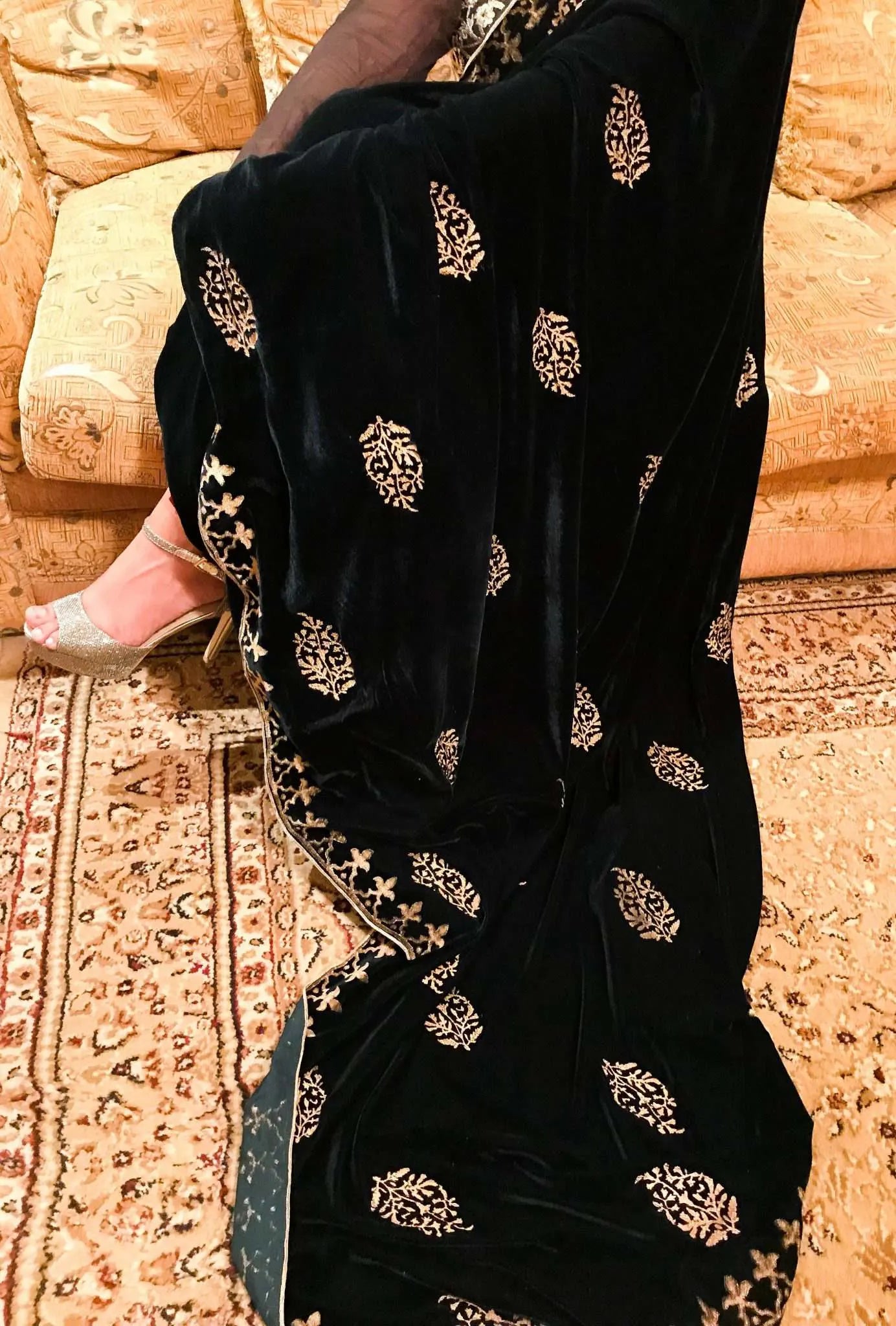 A elegantly draped velvet shawl showcasing floral patterns and block-printed border on all four sides in golden thread accents.