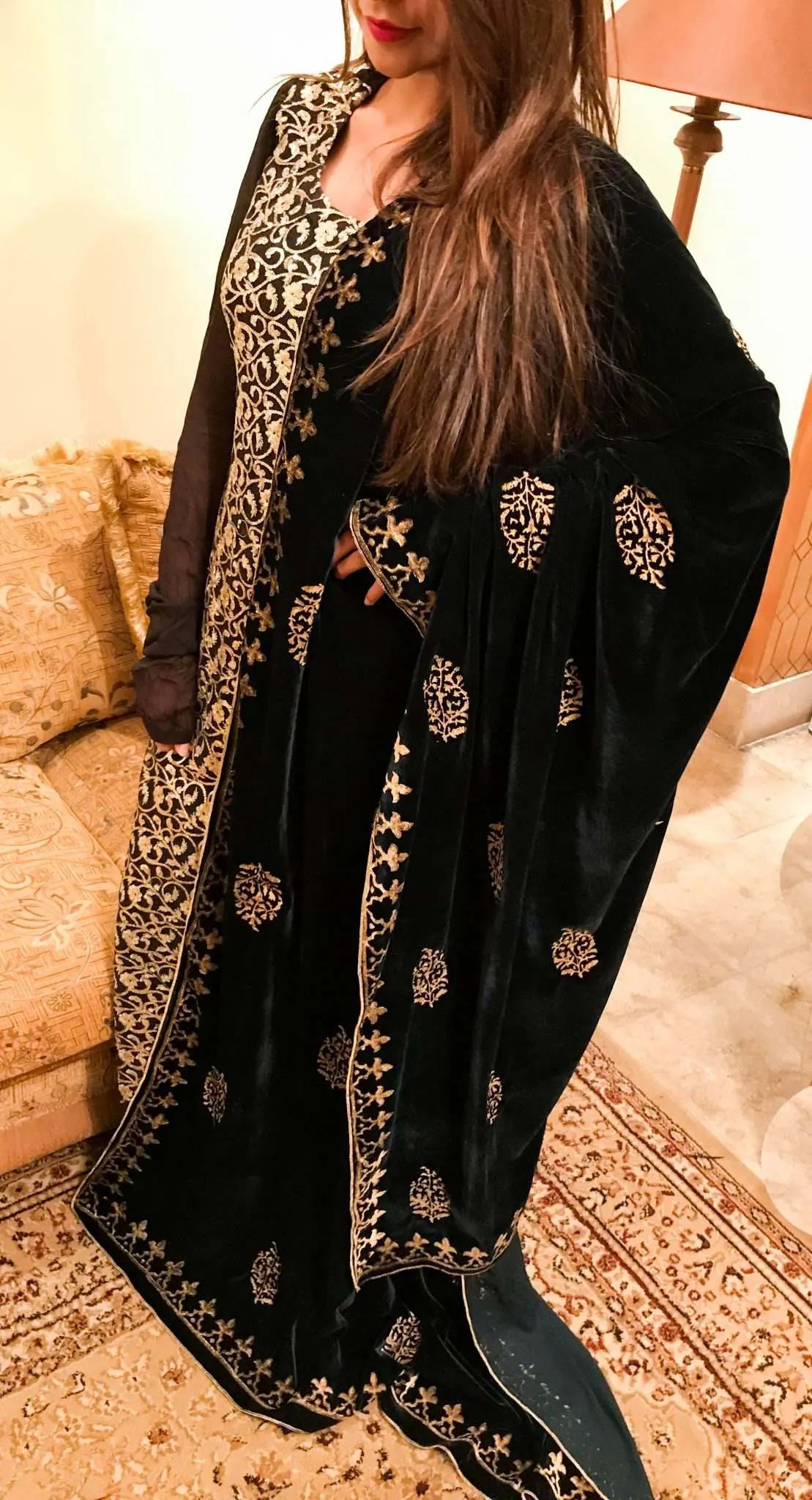 A elegantly draped velvet shawl showcasing floral patterns and block-printed border on all four sides in golden thread accents.