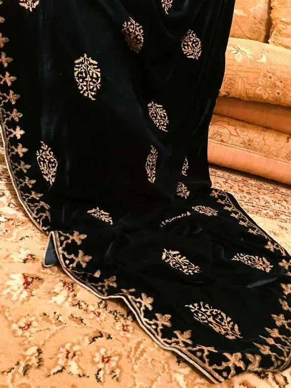 A elegantly draped velvet shawl showcasing floral patterns and block-printed border on all four sides in golden thread accents.