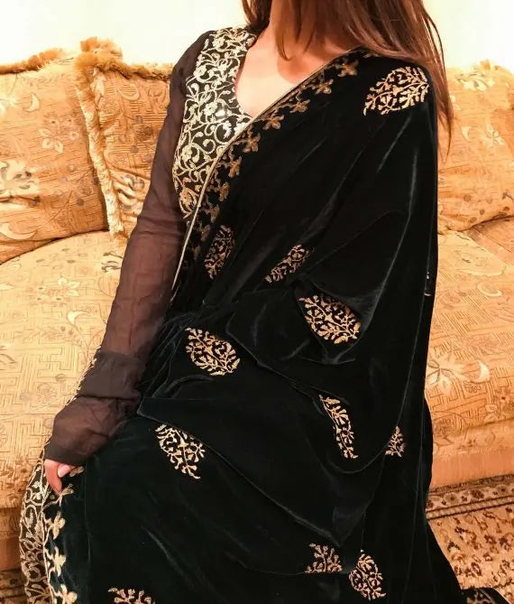 A elegantly draped velvet shawl showcasing floral patterns and block-printed border on all four sides in golden thread accents.