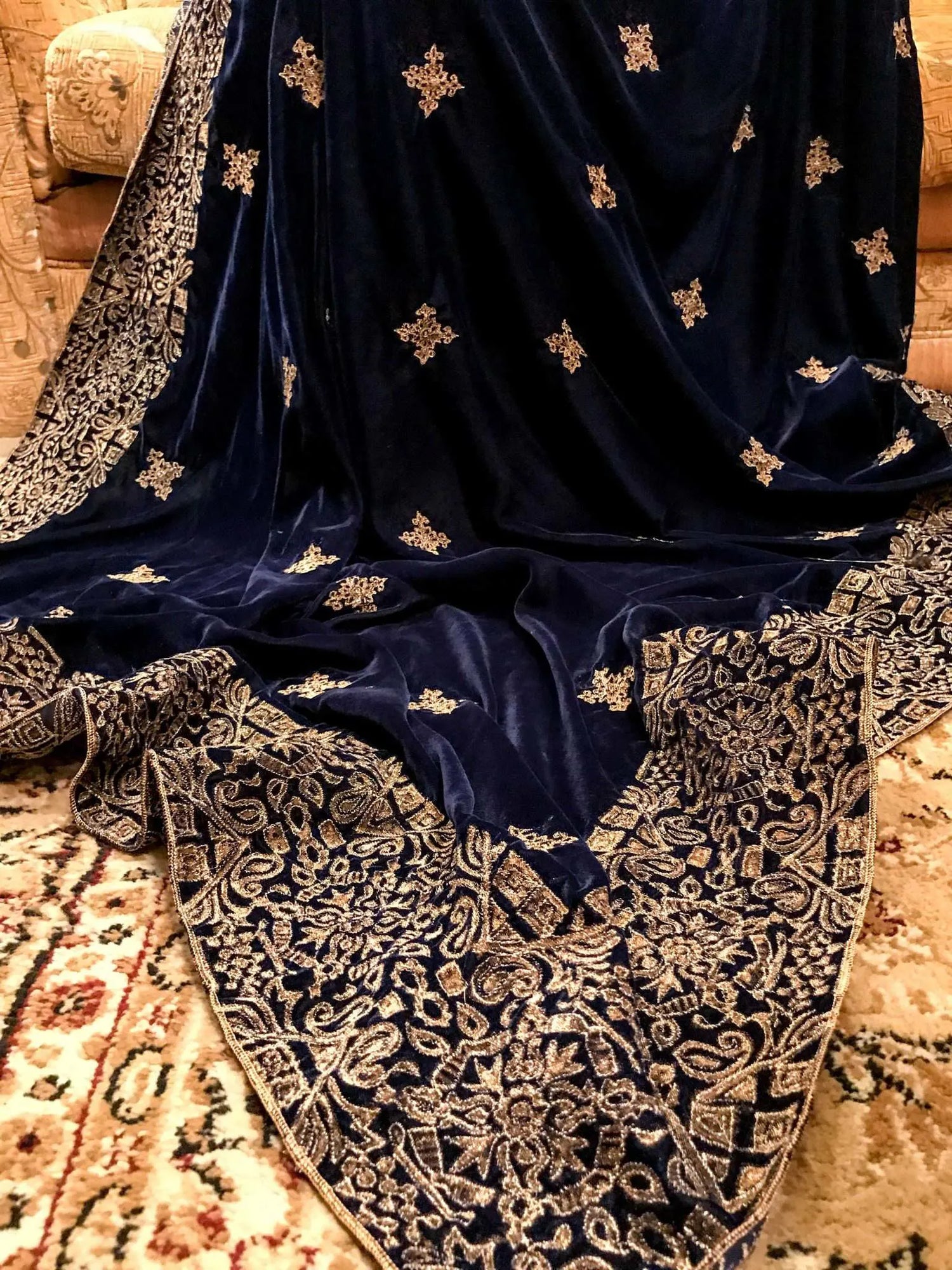 A luxurious velvet shawl with intricate geometric motifs first designed with block print and then outlined with shimmering golden accents.