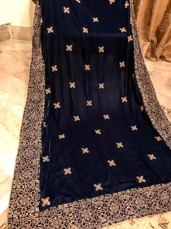 A luxurious velvet shawl with intricate geometric motifs first designed with block print and then outlined with shimmering golden accents.