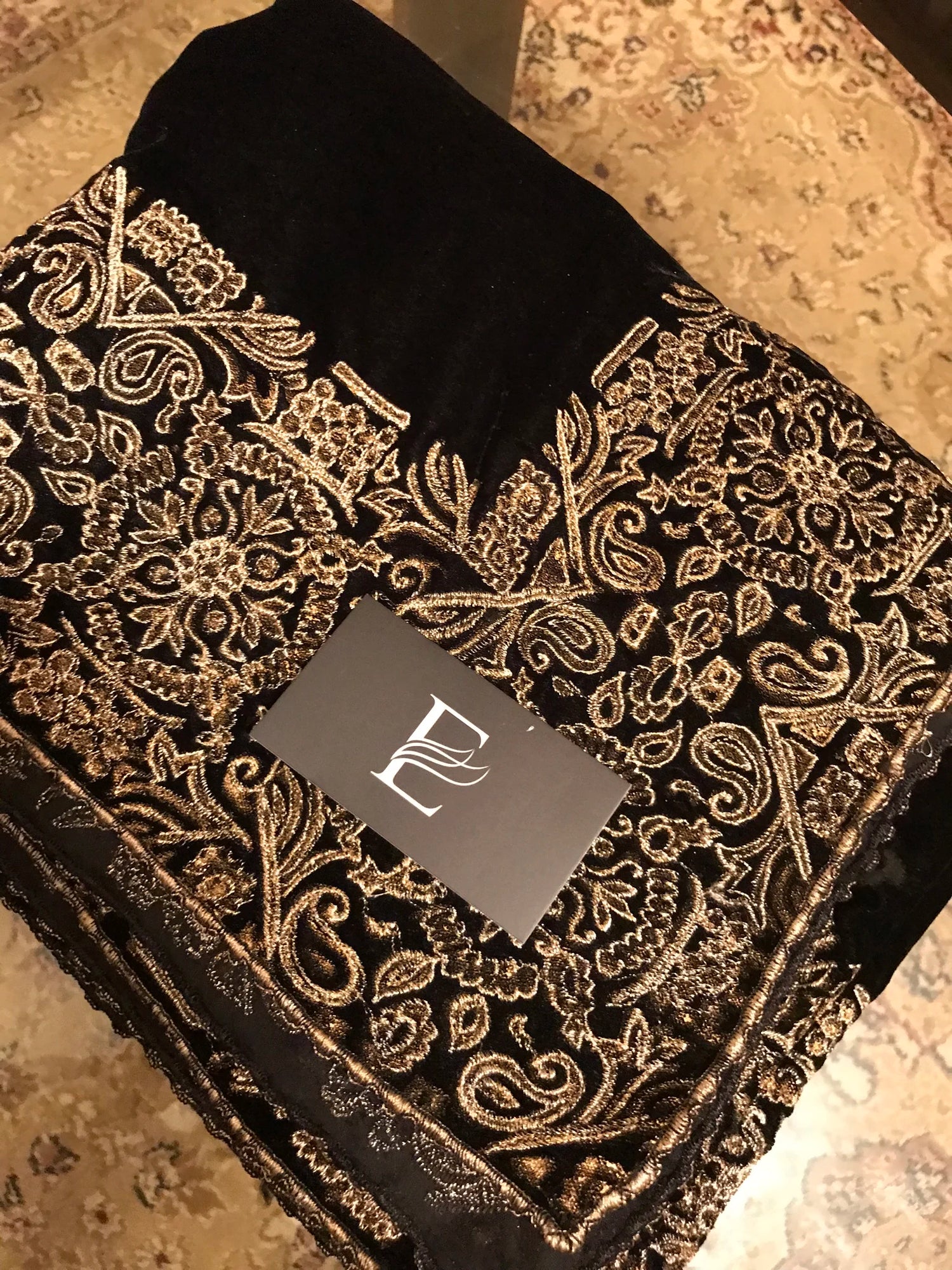 A luxurious velvet shawl with intricate geometric motifs first designed with block print and then outlined with shimmering golden accents.