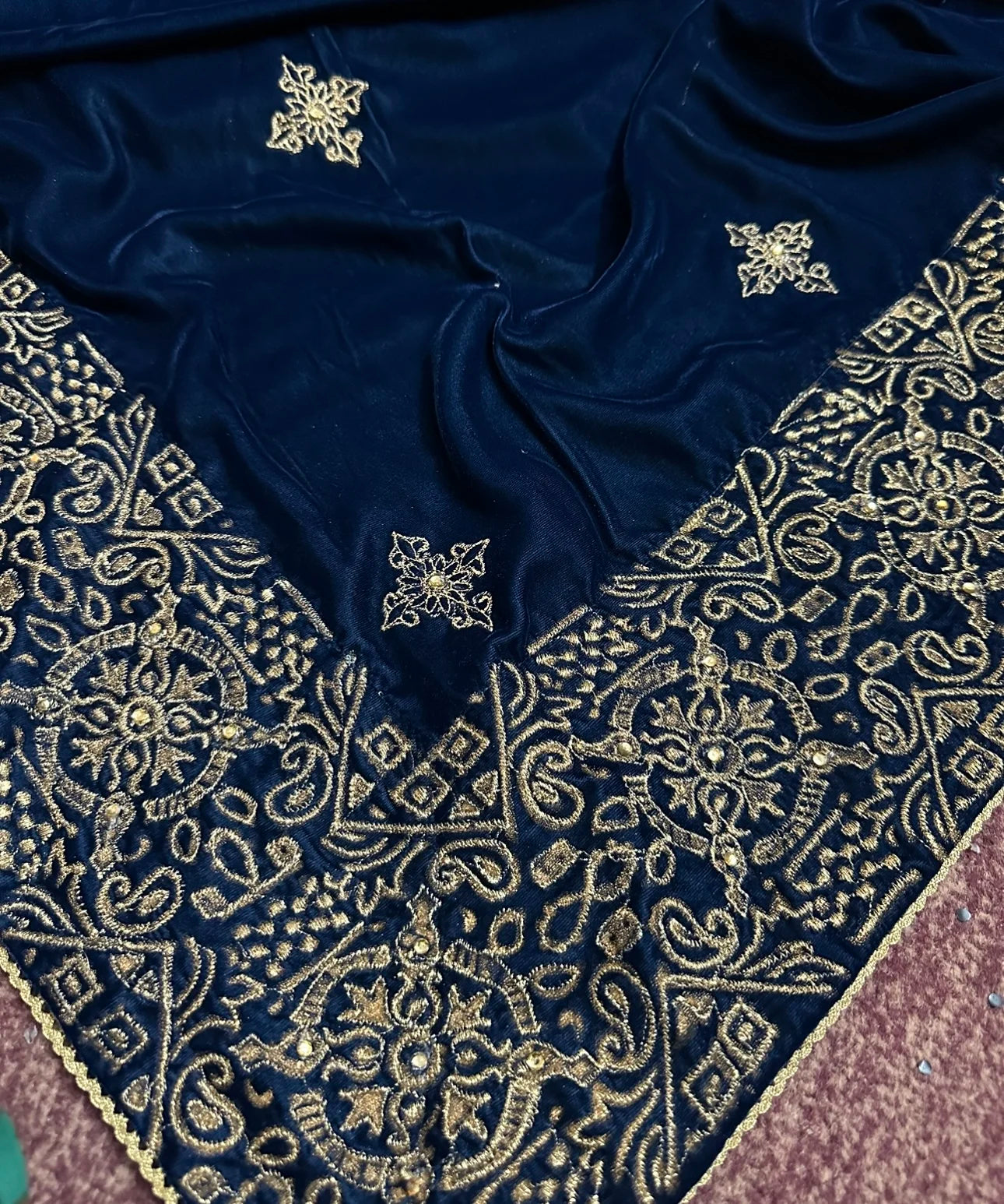 A luxurious velvet shawl with intricate geometric motifs first designed with block print and then outlined with shimmering golden accents.