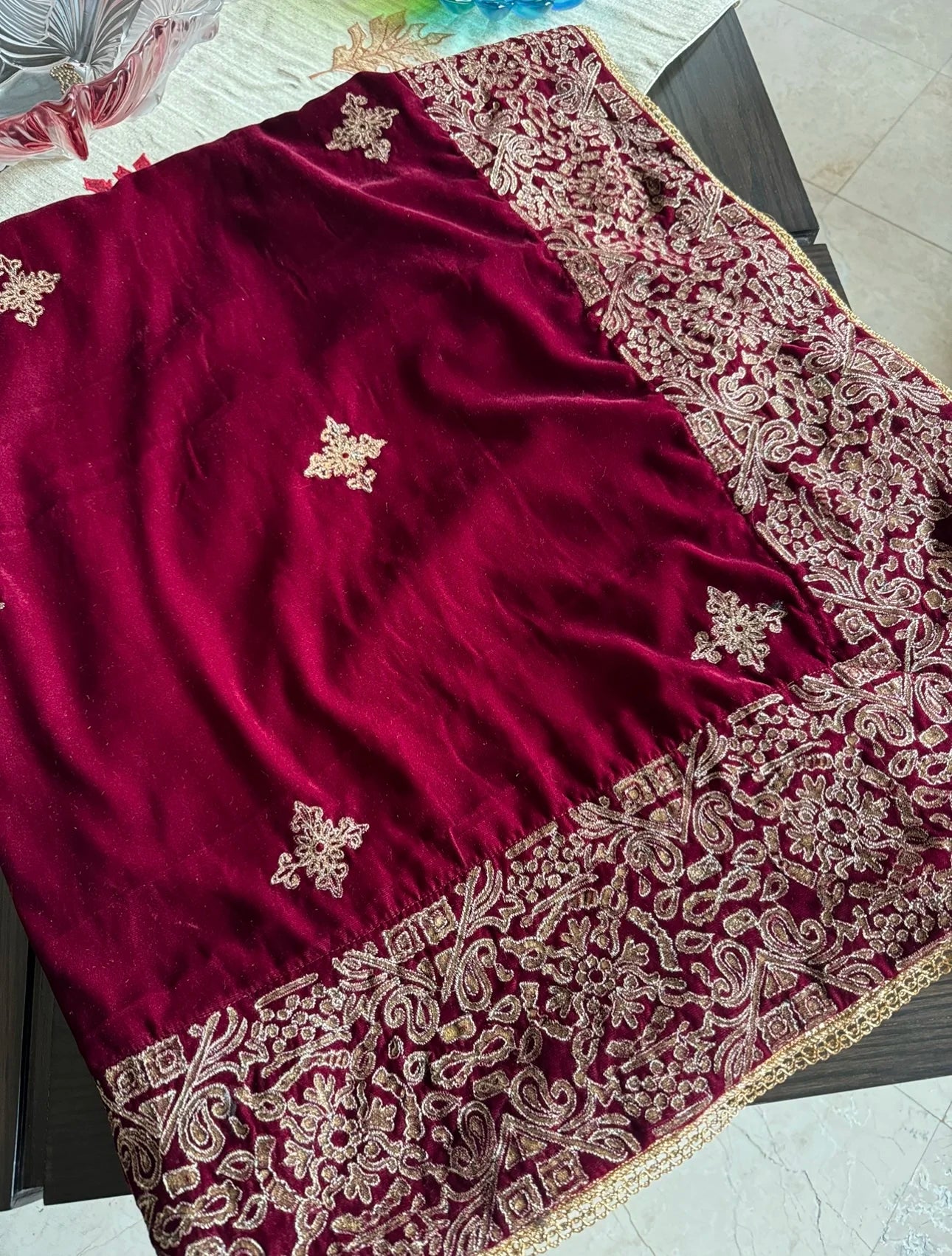 A luxurious velvet shawl with intricate geometric motifs first designed with block print and then outlined with shimmering golden accents.