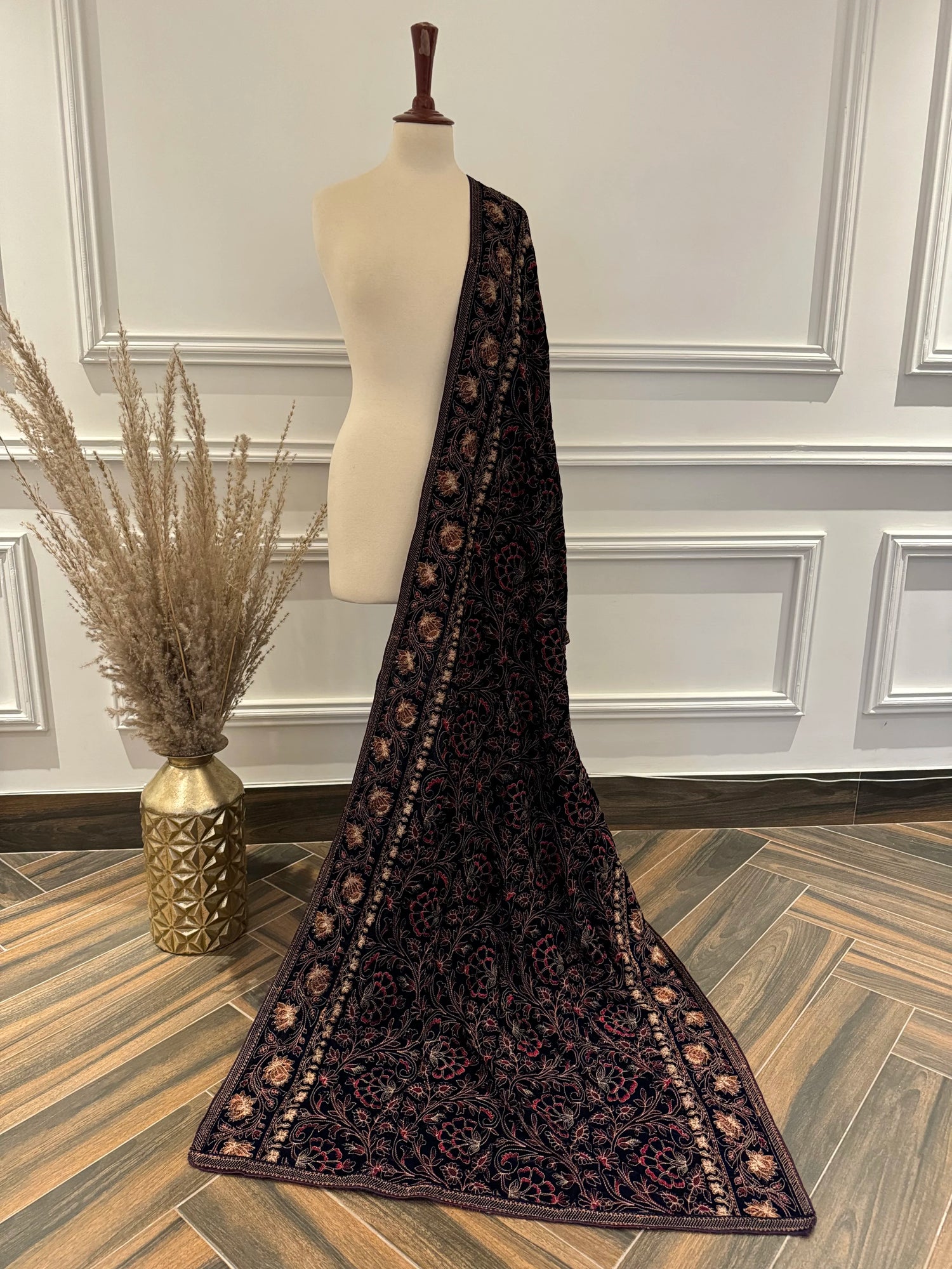 Luxurious black and gold floral shawl with a vibrant red border, highlighting exquisite multi-thread embroidery on soft velvet.