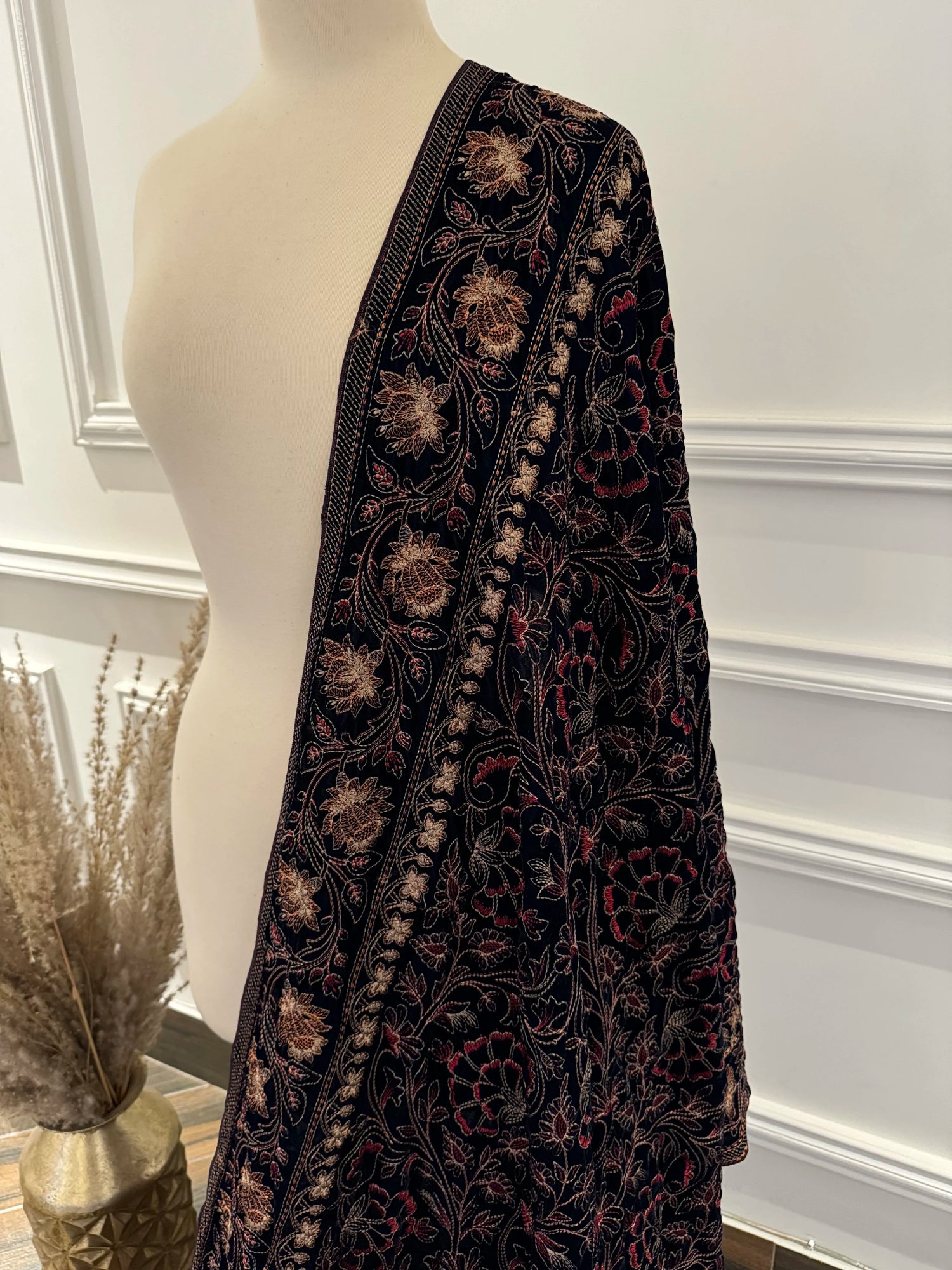 Luxurious black and gold floral shawl with a vibrant red border, highlighting exquisite multi-thread embroidery on soft velvet.