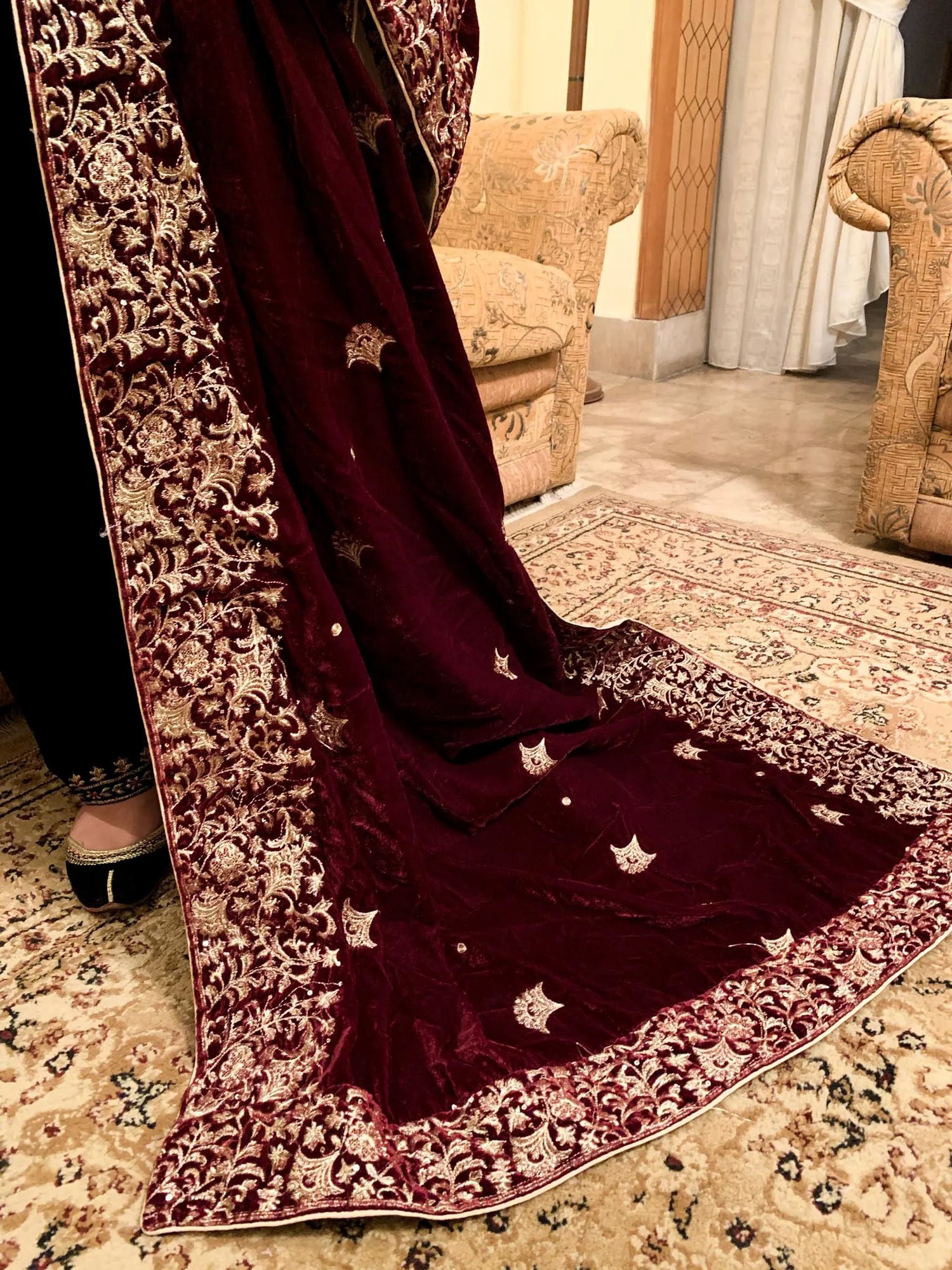 A delicate maroon velvet shawl adorned with exquisite embroidery and a fine boti pattern for elegance.