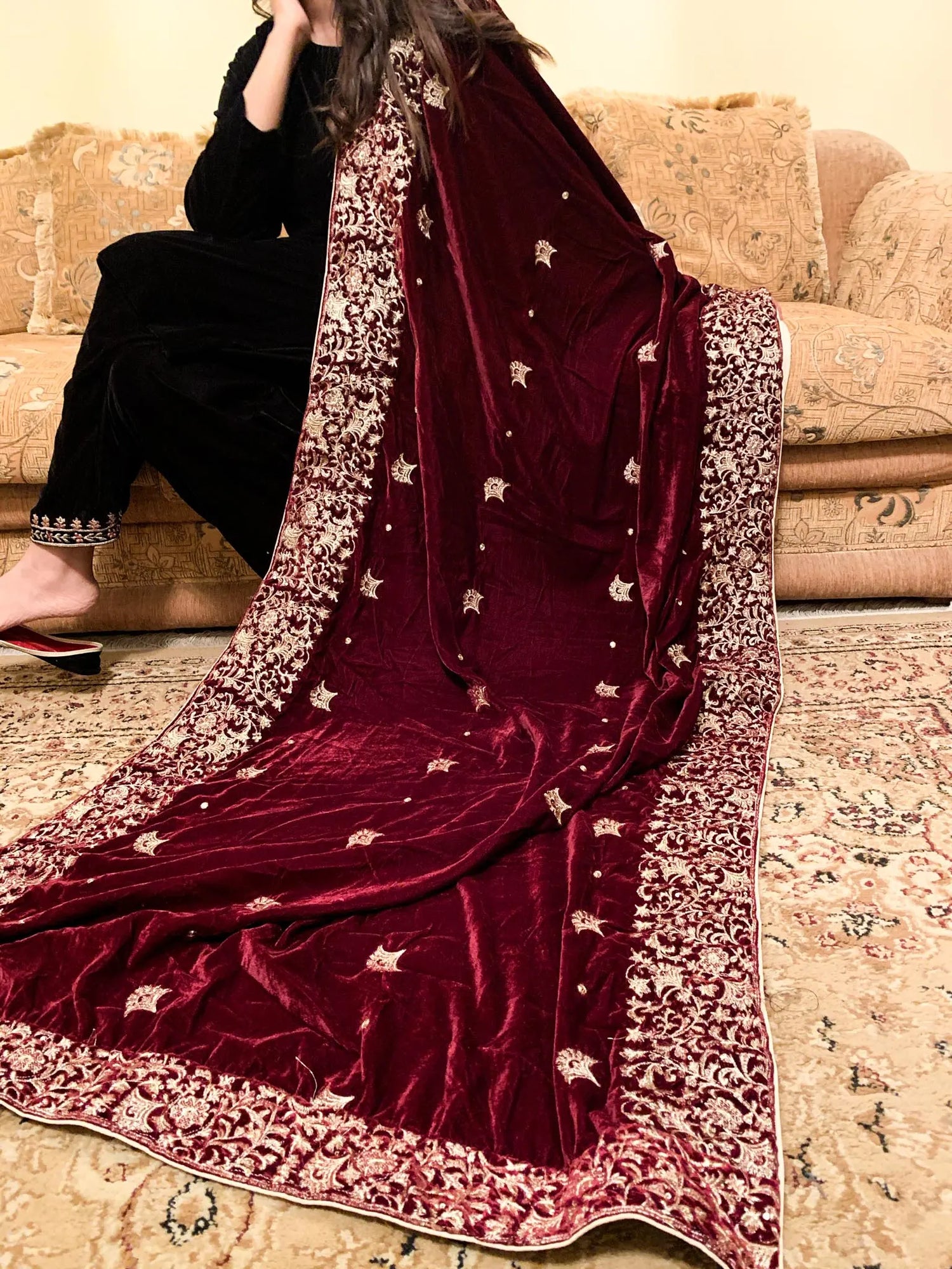 A delicate maroon velvet shawl adorned with exquisite embroidery and a fine boti pattern for elegance.