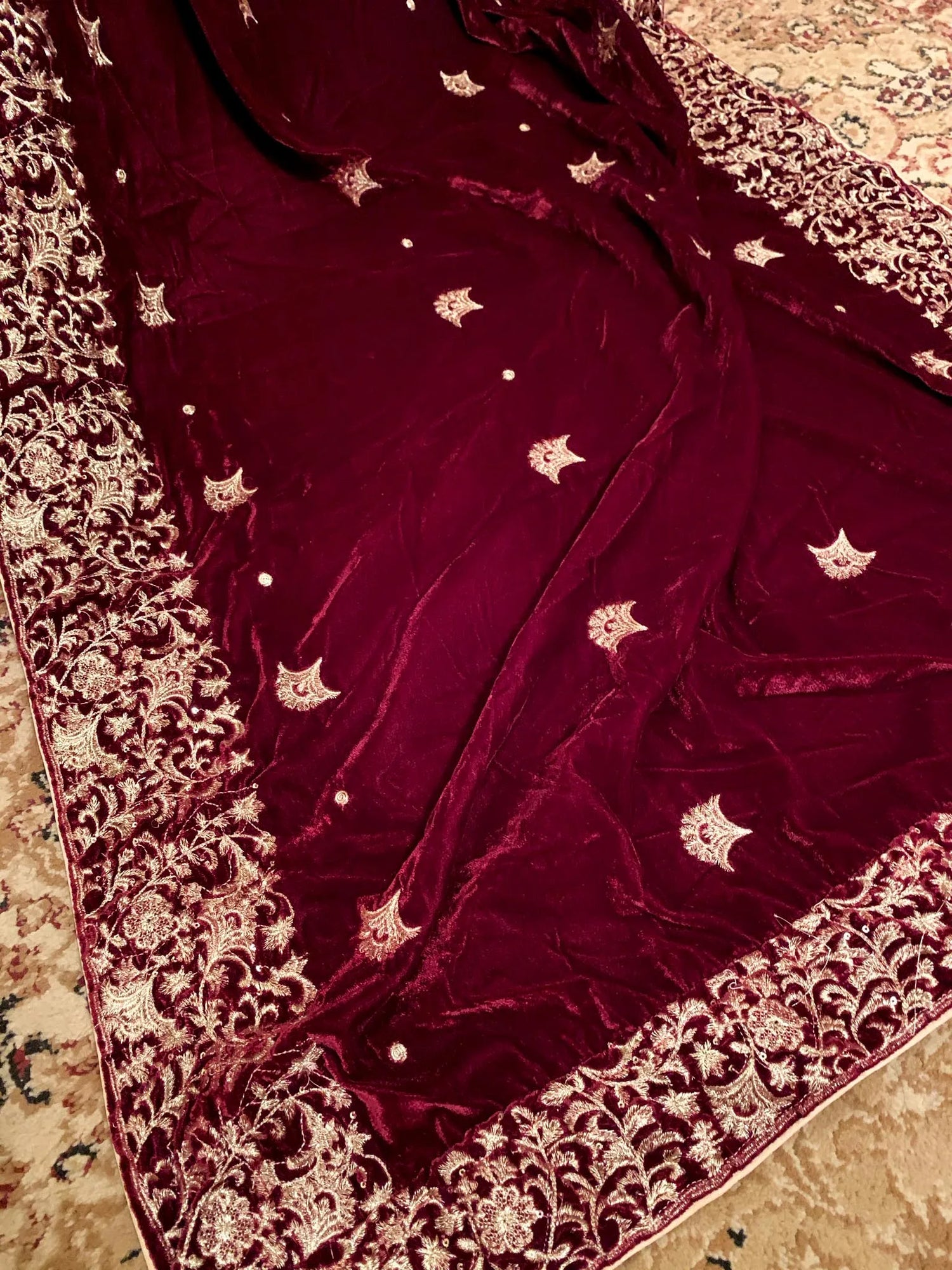 A delicate maroon velvet shawl adorned with exquisite embroidery and a fine boti pattern for elegance.