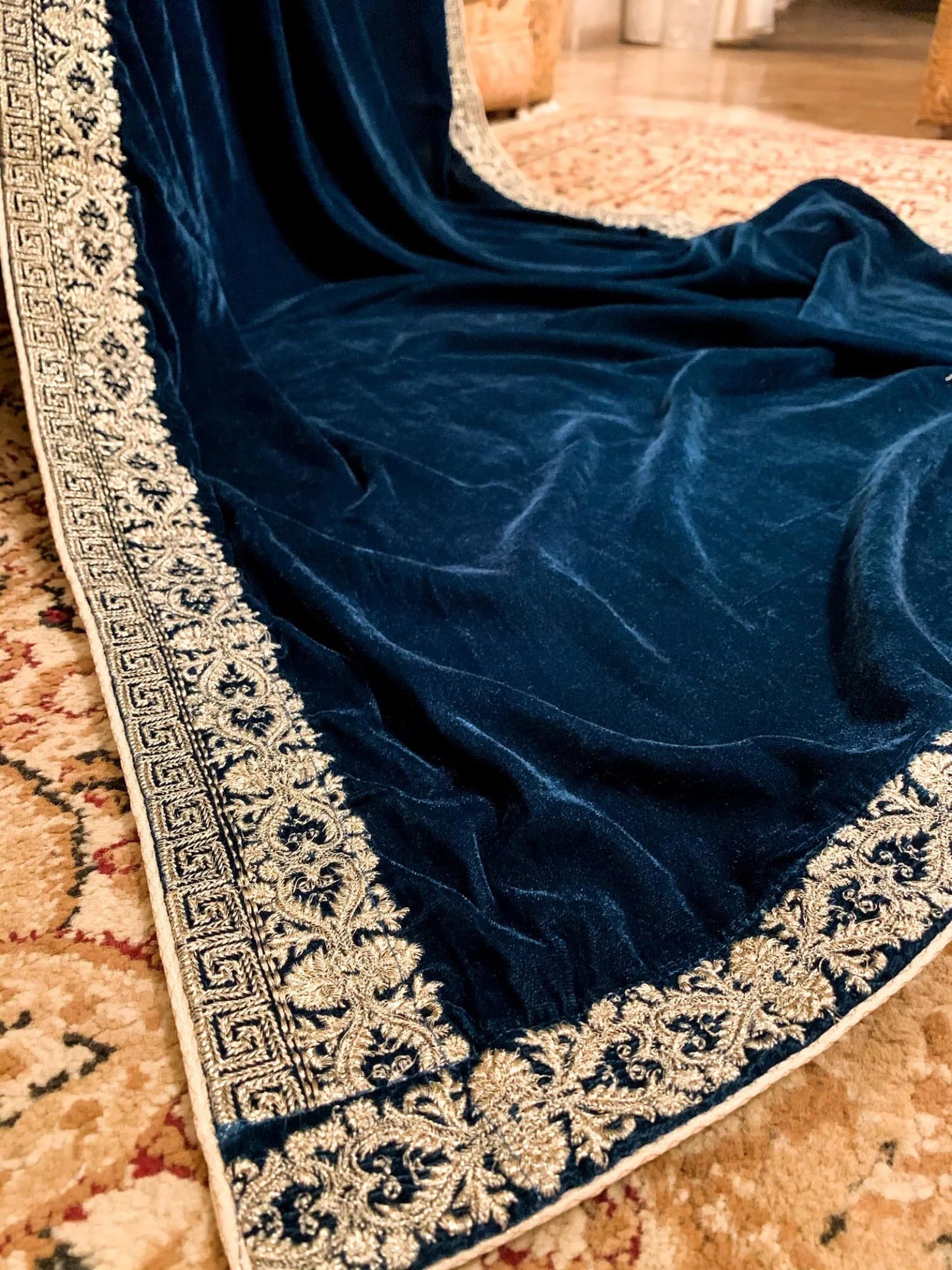 A luxurious velvet shawl featuring detailed geometric tila embroidery, showcasing elegance and sophistication.