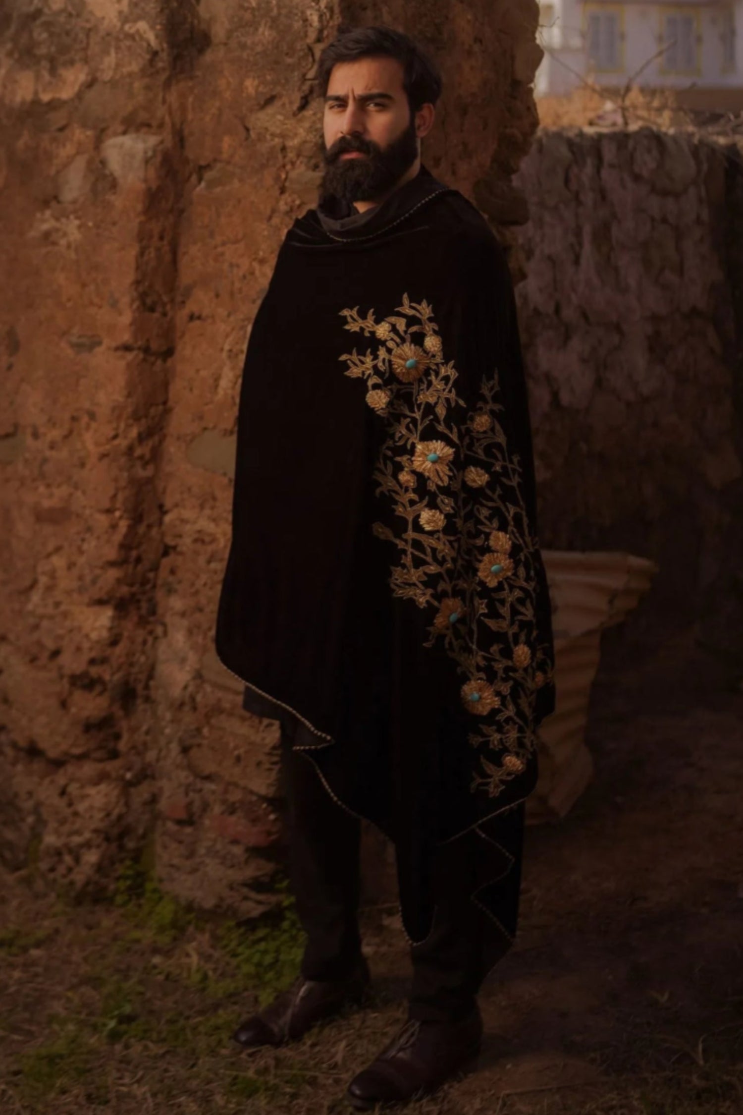 A velvet shawl adored with tila embroidery, feroza stone work and block printed floral motifs, embodying a blend of elegance and traditional charm.