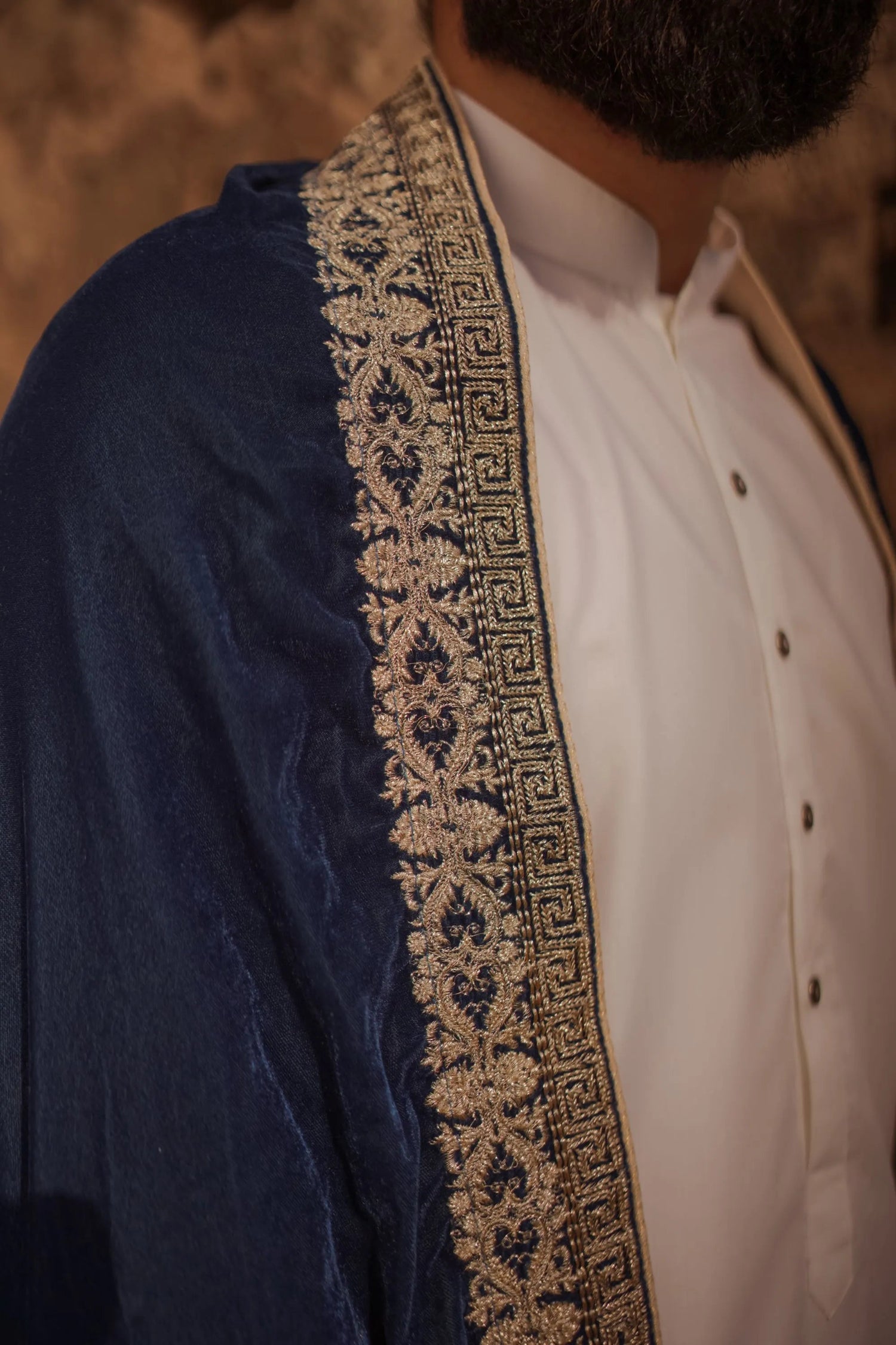 A premium velvet shawl featuring intricate four-sided geometric Greek tila embroidery, showing timeless unisex design for formal and festive wear.