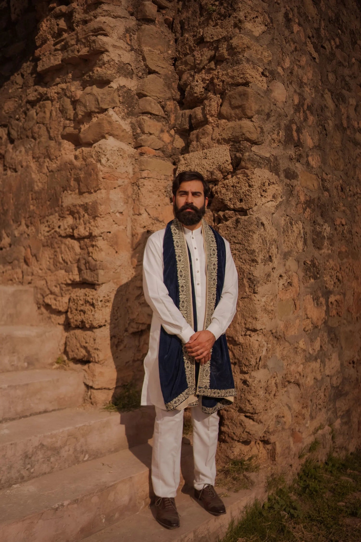 A premium velvet shawl featuring intricate four-sided geometric Greek tila embroidery, showing timeless unisex design for formal and festive wear.
