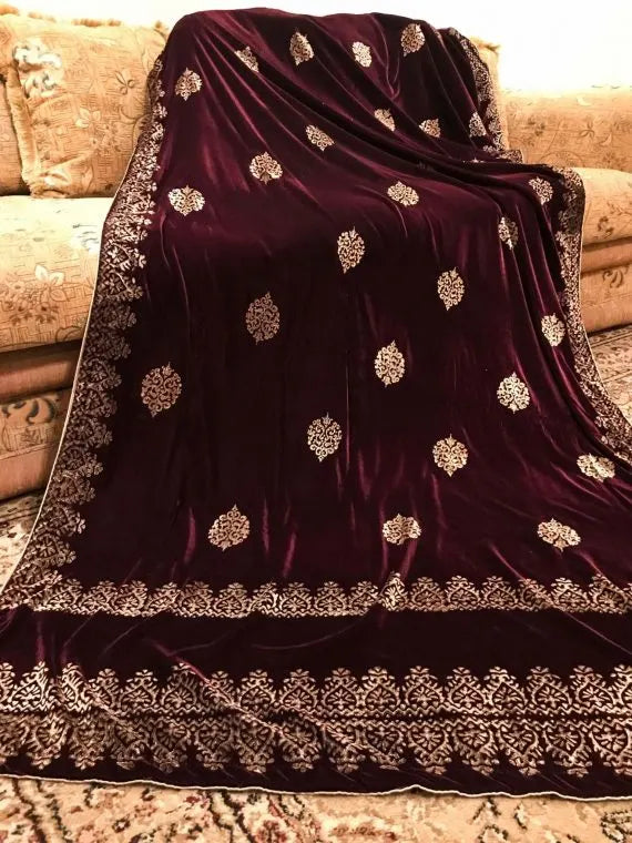 Elegant velvet shawl with gold embroidery, featuring intricate motifs and tassels, perfect for elegant occasions.