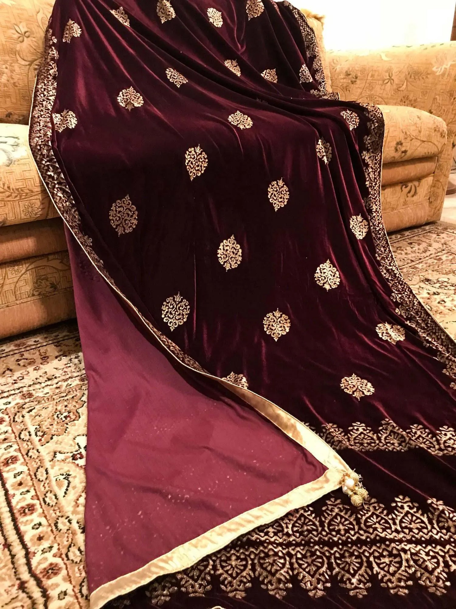 Elegant velvet shawl with gold embroidery, featuring intricate motifs and tassels, perfect for elegant occasions.