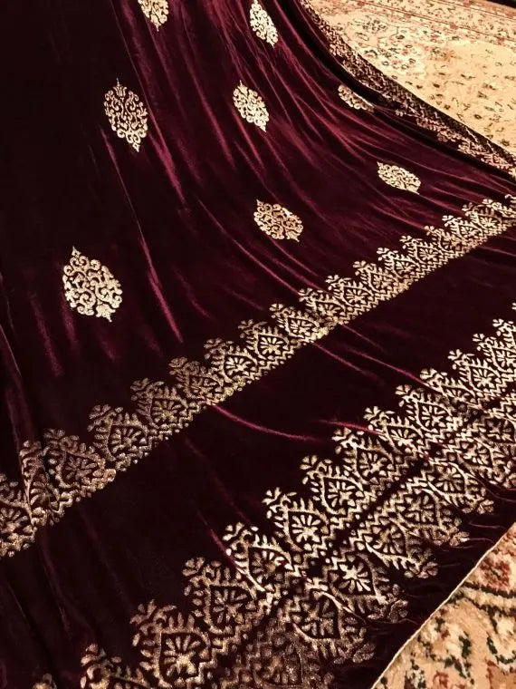 Elegant velvet shawl with gold embroidery, featuring intricate motifs and tassels, perfect for elegant occasions.