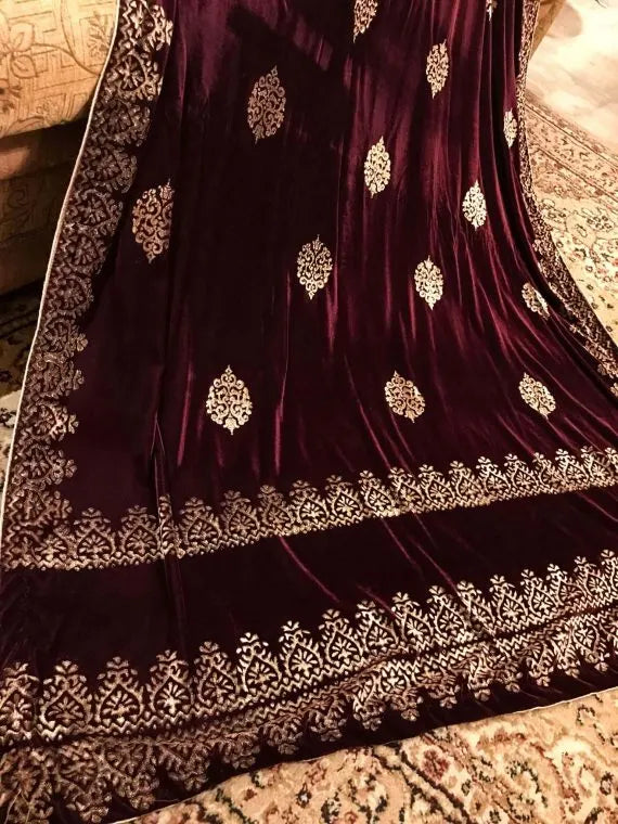 Elegant velvet shawl with gold embroidery, featuring intricate motifs and tassels, perfect for elegant occasions.