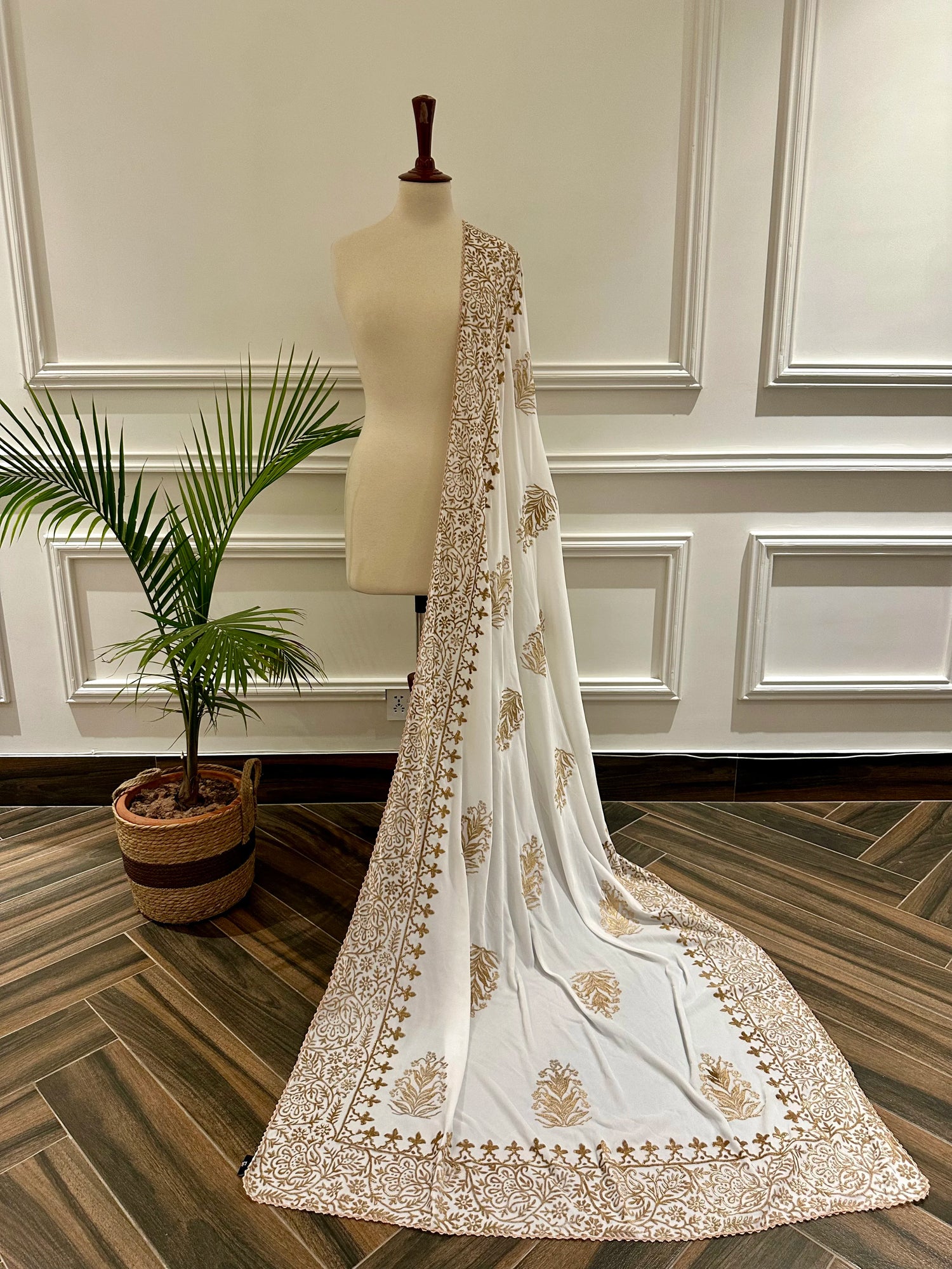 White and gold embroidered velvet shawl featuring a luxurious gold block printed border, showcasing intricate craftsmanship and elegant design.
