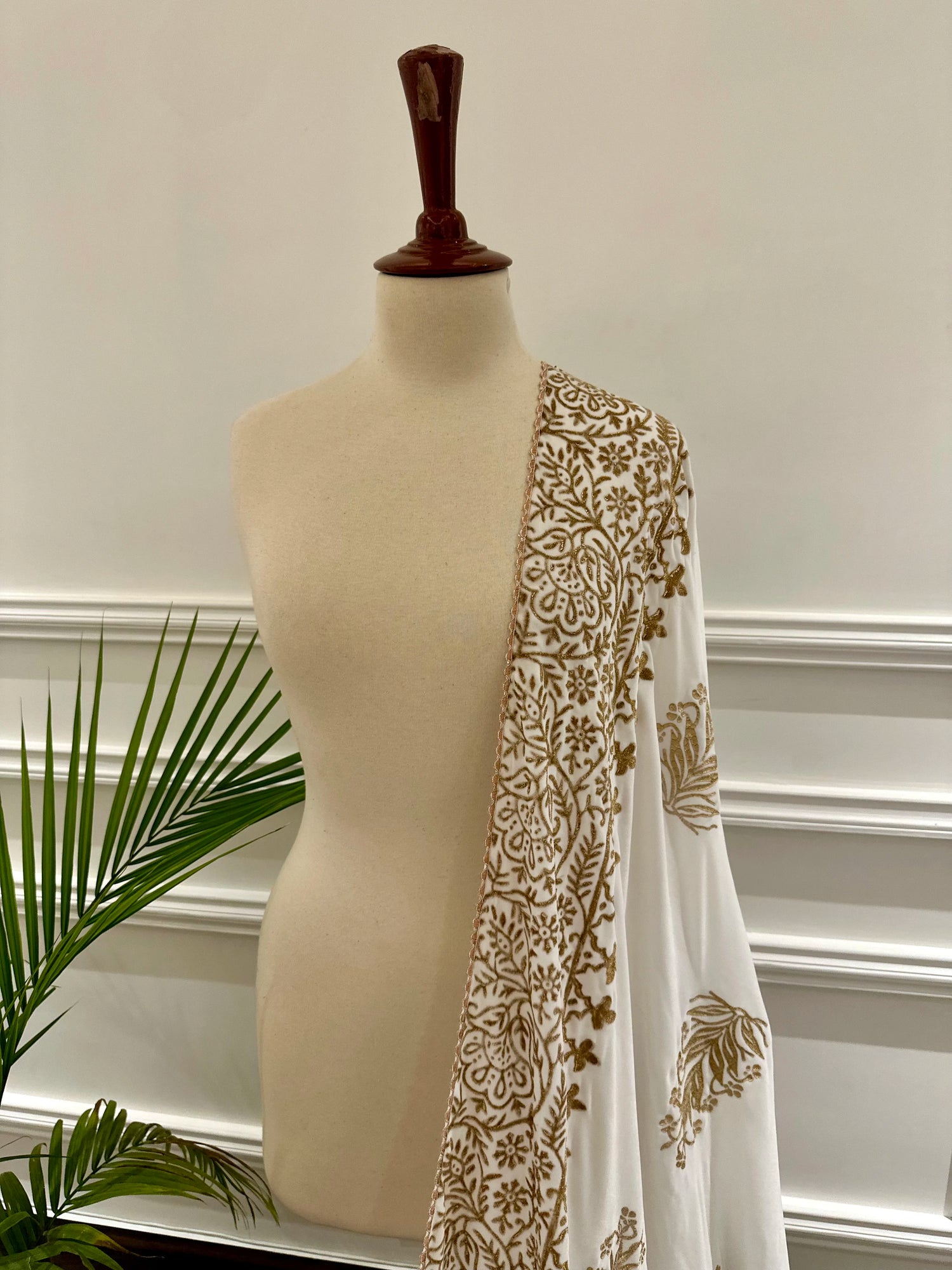 White and gold embroidered velvet shawl featuring a luxurious gold block printed border, showcasing intricate craftsmanship and elegant design.