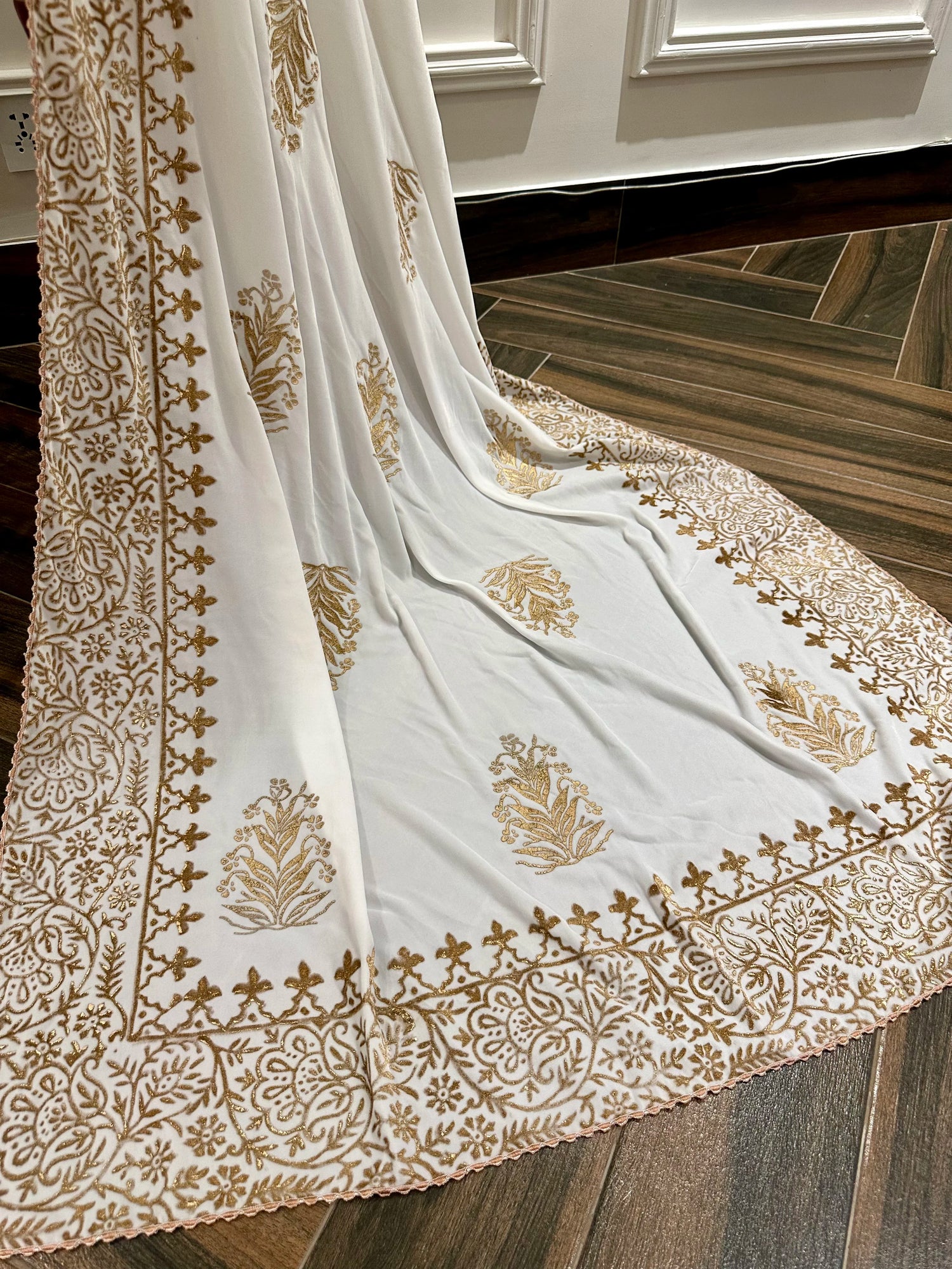 White and gold embroidered velvet shawl featuring a luxurious gold block printed border, showcasing intricate craftsmanship and elegant design.