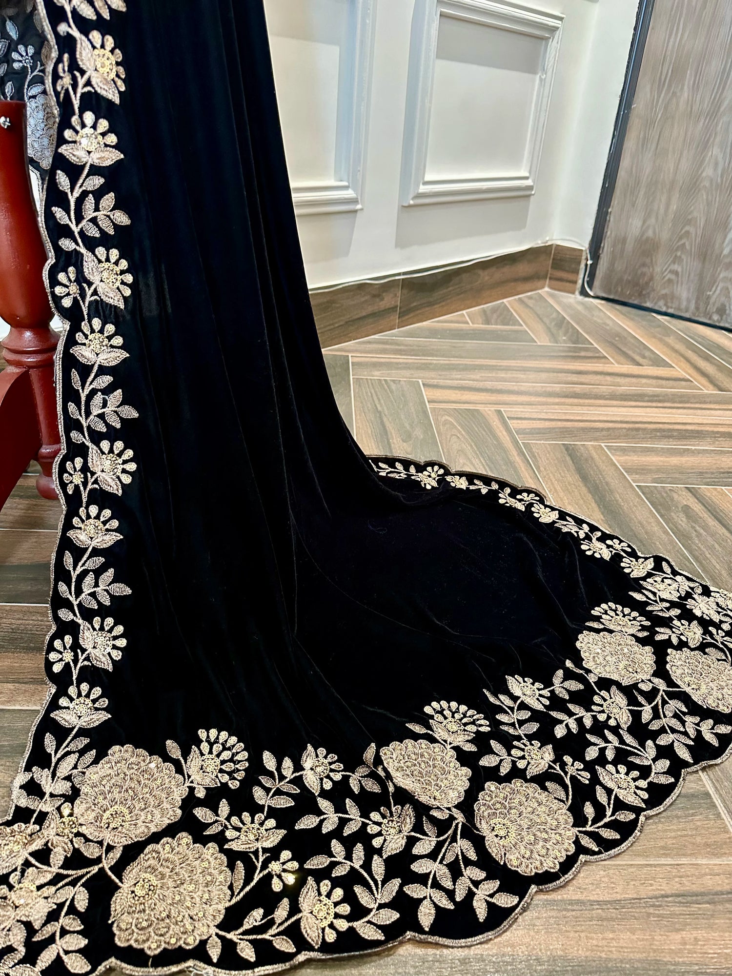 Elevate your style with velvet shawl featuring heavy floral tila and sequin embroidery, floral cutwork borders, and decorative floral bunches on pallu. Ideal for festive events.