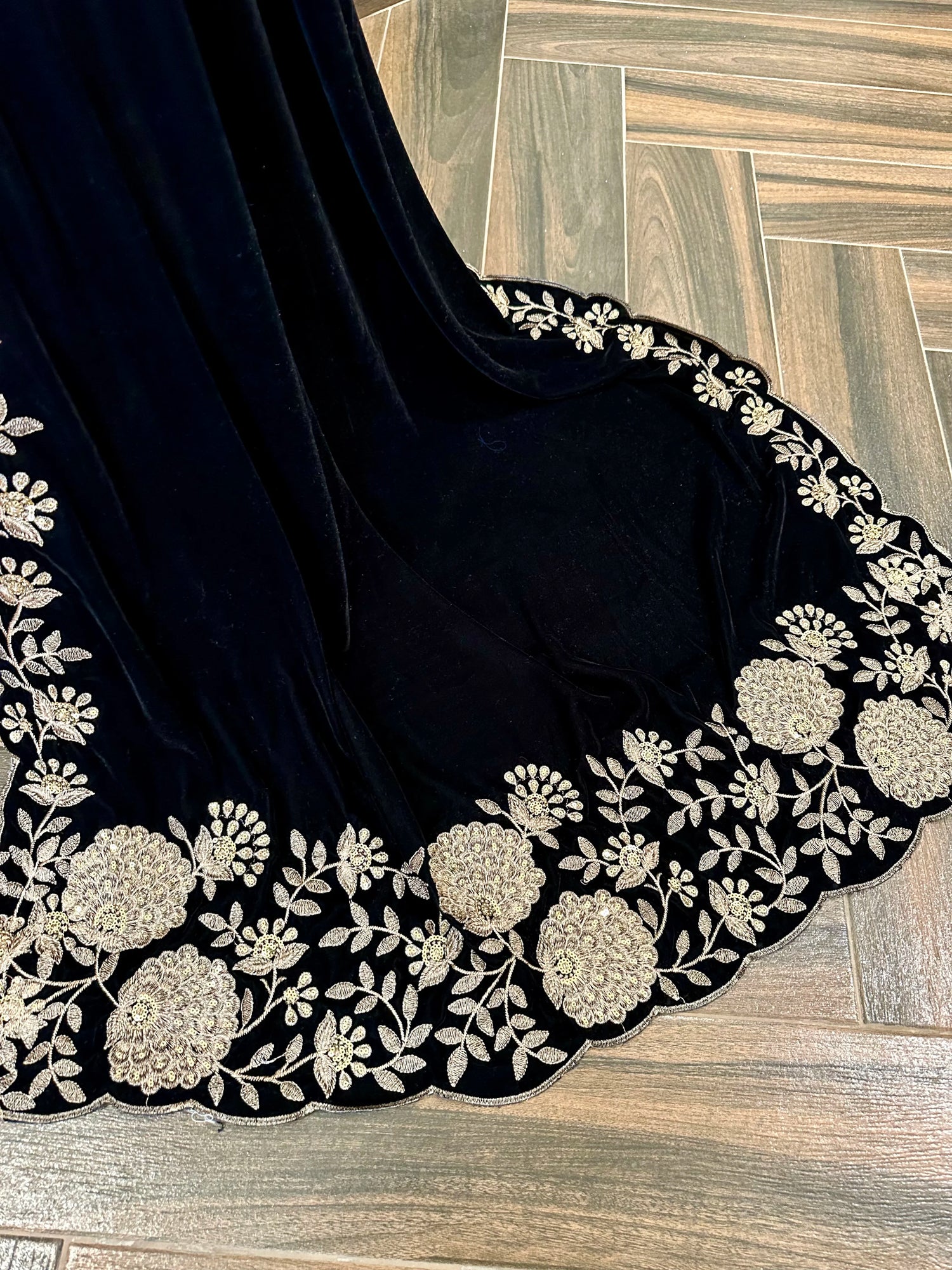 Elevate your style with velvet shawl featuring heavy floral tila and sequin embroidery, floral cutwork borders, and decorative floral bunches on pallu. Ideal for festive events.