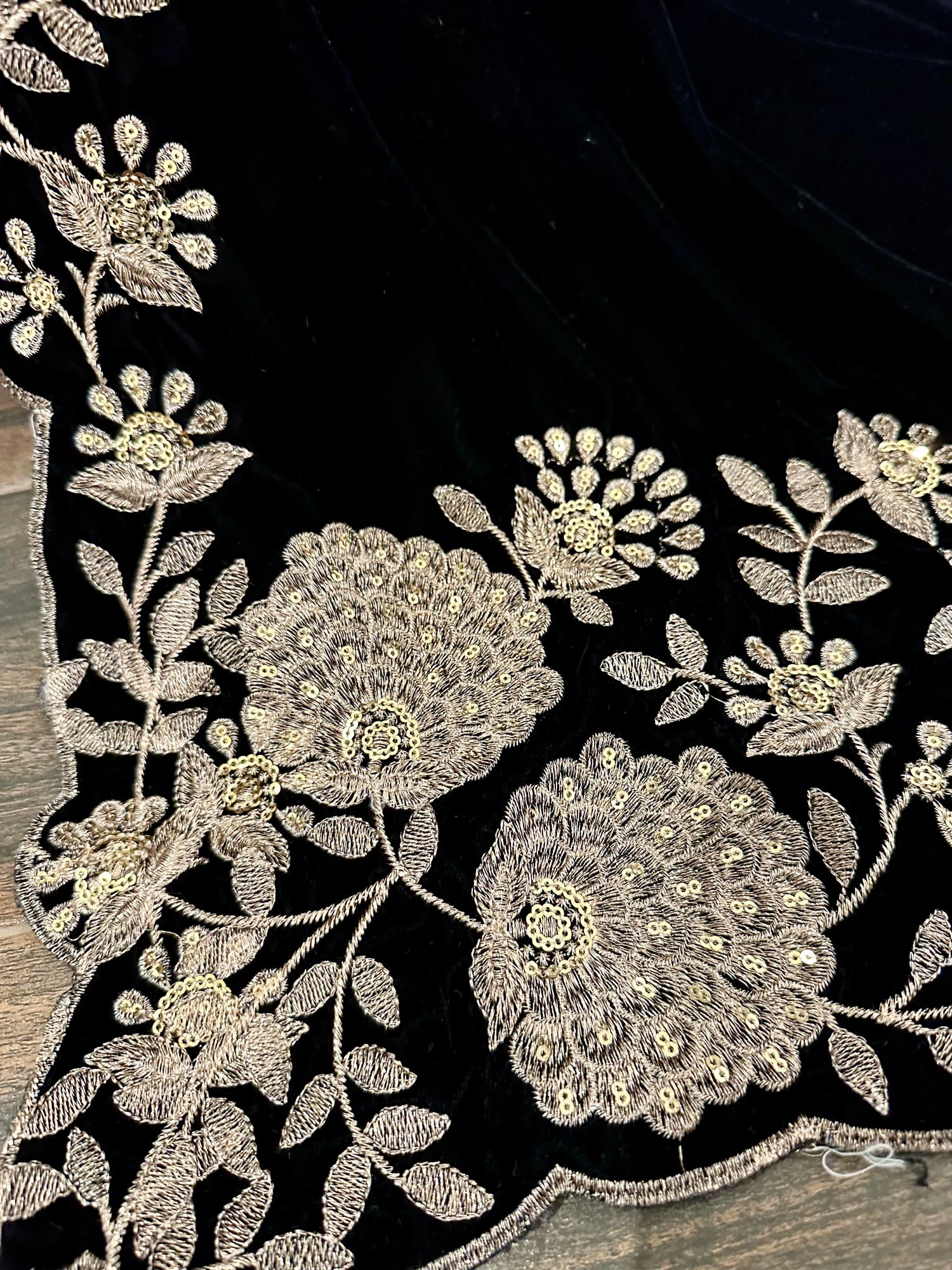 Elevate your style with velvet shawl featuring heavy floral tila and sequin embroidery, floral cutwork borders, and decorative floral bunches on pallu. Ideal for festive events.