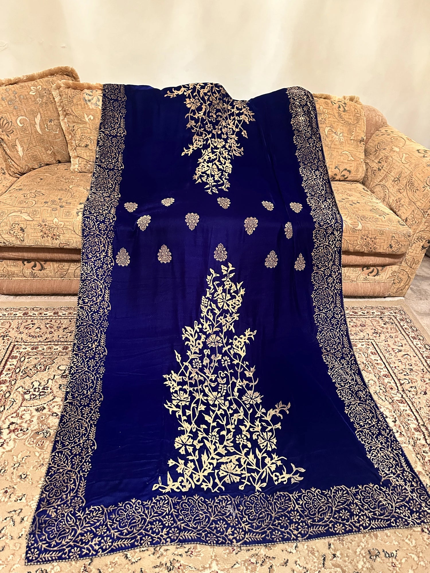 Royal blue velvet shawl with intricate antique gold tilla embroidery with heavy border and premium fabric texture, ideal for festive events.