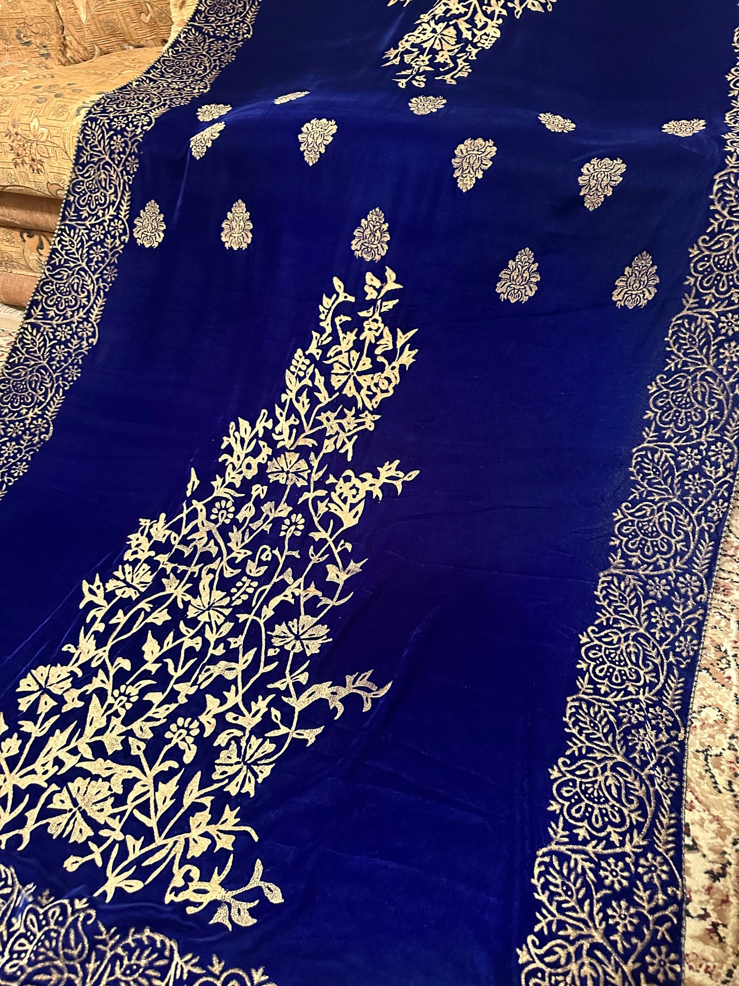 Royal blue velvet shawl with intricate antique gold tilla embroidery with heavy border and premium fabric texture, ideal for festive events.