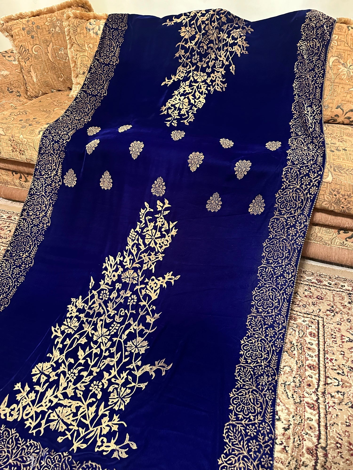 Royal blue velvet shawl with intricate antique gold tilla embroidery with heavy border and premium fabric texture, ideal for festive events.
