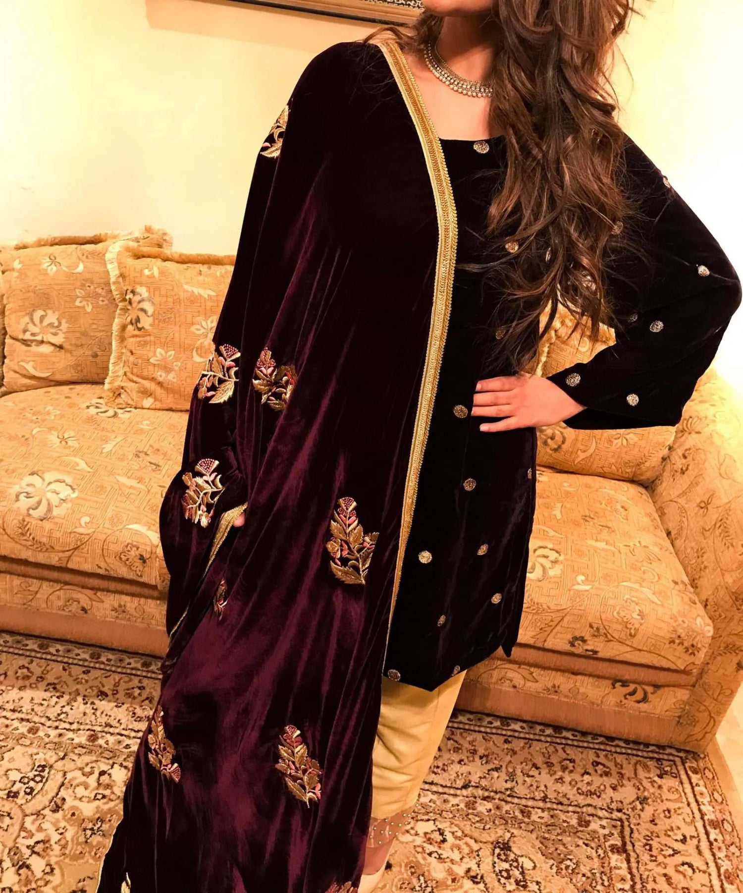 A luxurious velvet shawl featuring intricate gold embroidery and floral designs, exuding elegance, highlighting refined craftsmanship  and sophistication.
