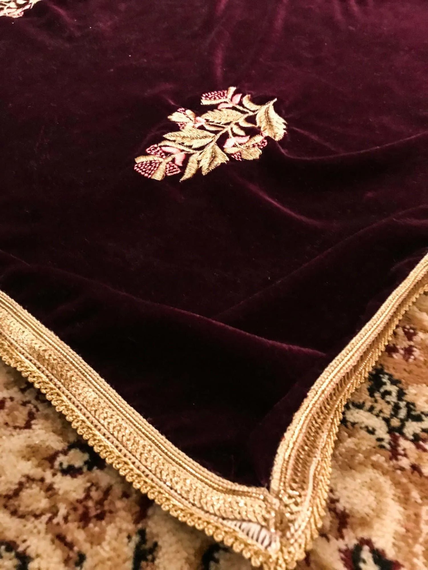 A luxurious velvet shawl featuring intricate gold embroidery and floral designs, exuding elegance, highlighting refined craftsmanship  and sophistication.