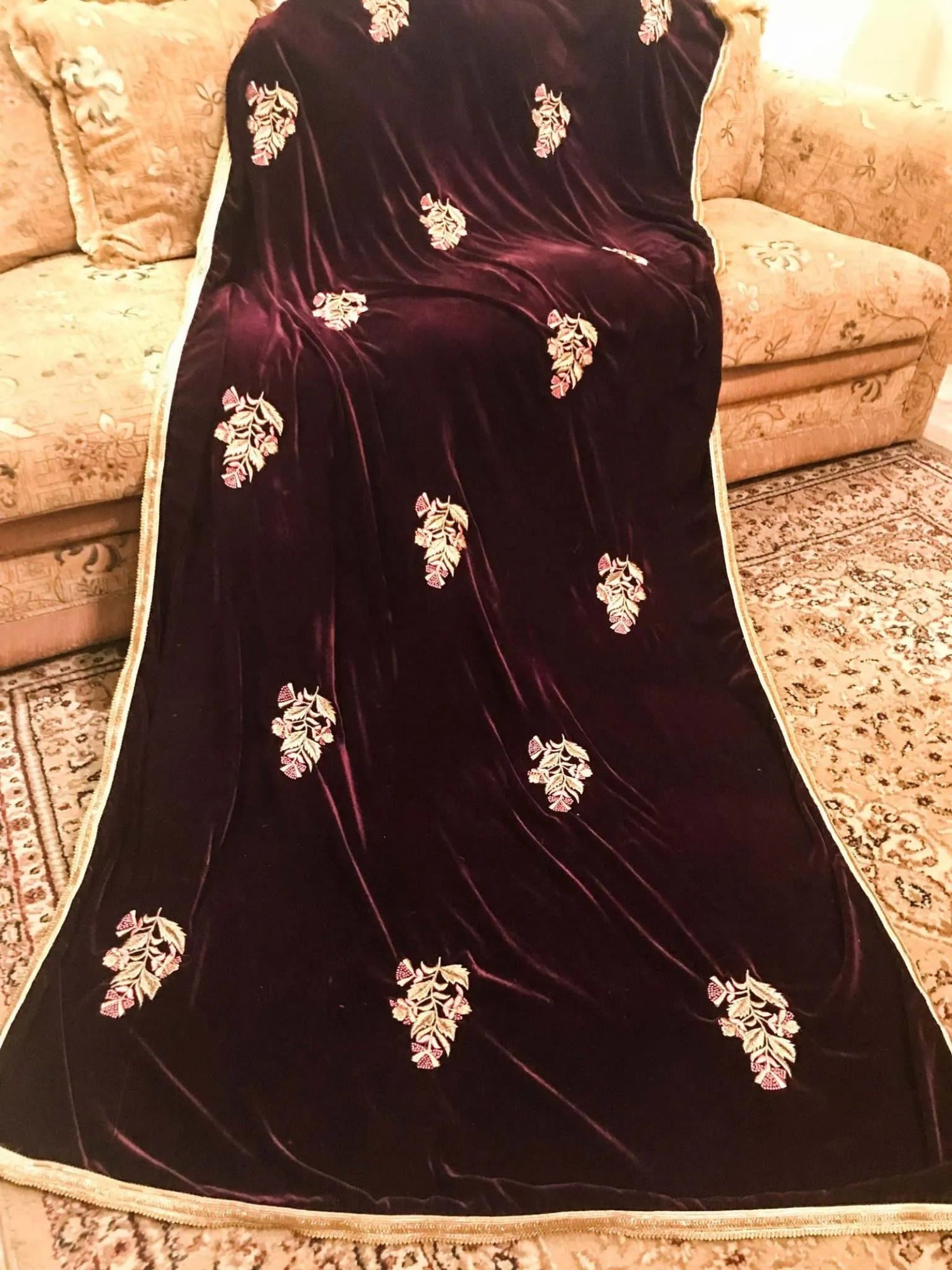 A luxurious velvet shawl featuring intricate gold embroidery and floral designs, exuding elegance, highlighting refined craftsmanship  and sophistication.