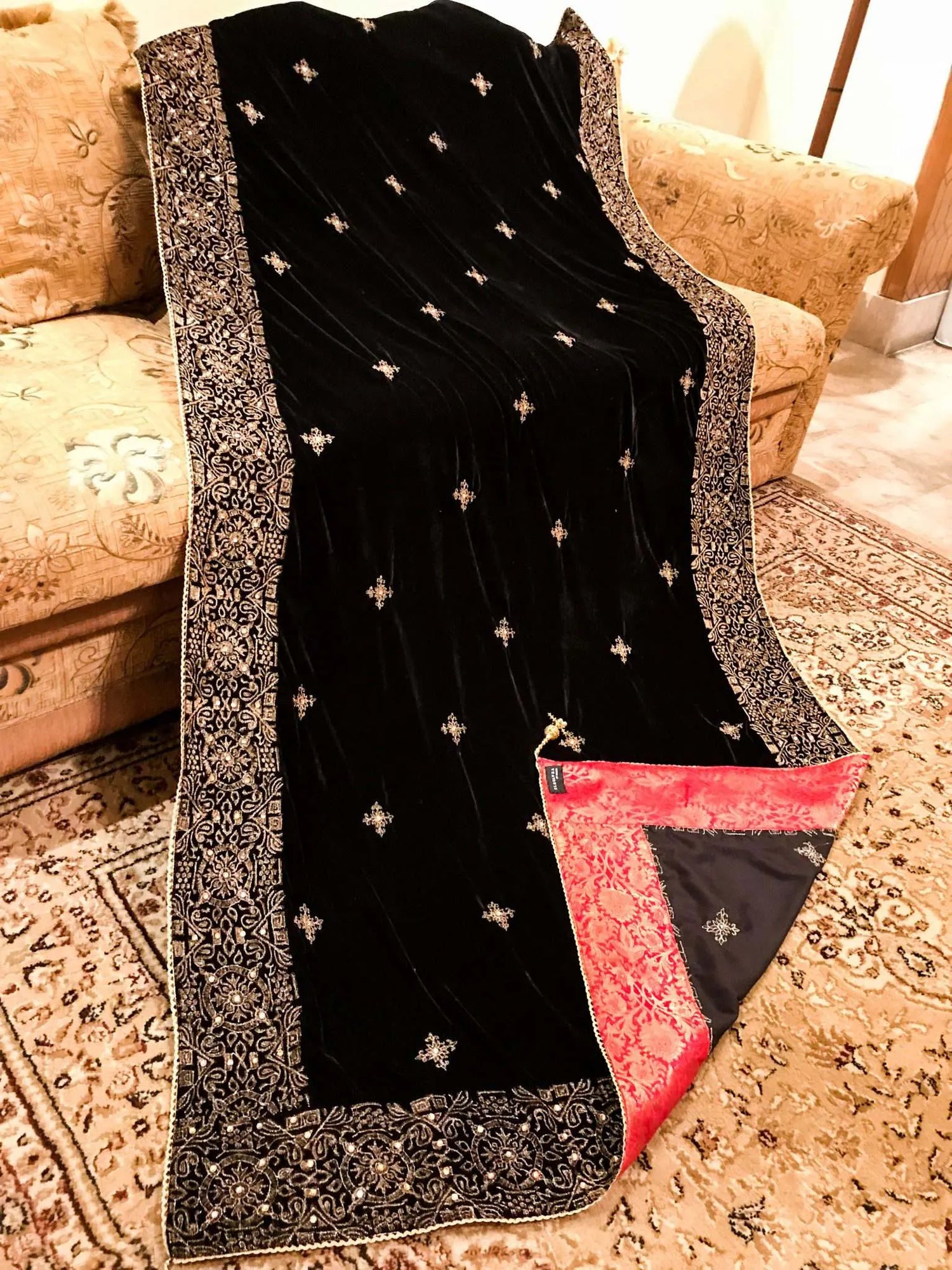 Luxurious velvet shawl adorned with gold tila embroidery, stone work and tassels, ideal for enhancing festive and formal attire.