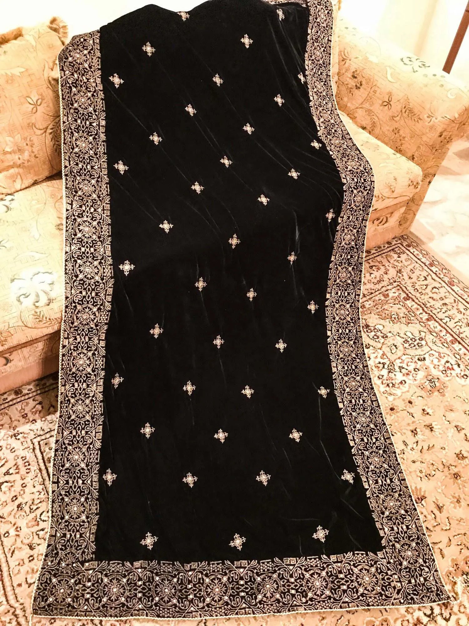 Luxurious velvet shawl adorned with gold tila embroidery, stone work and tassels, ideal for enhancing festive and formal attire.