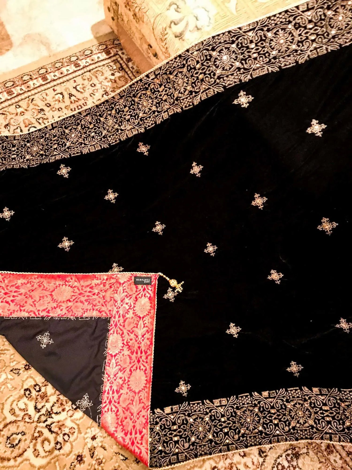 Luxurious velvet shawl adorned with gold tila embroidery, stone work and tassels, ideal for enhancing festive and formal attire.
