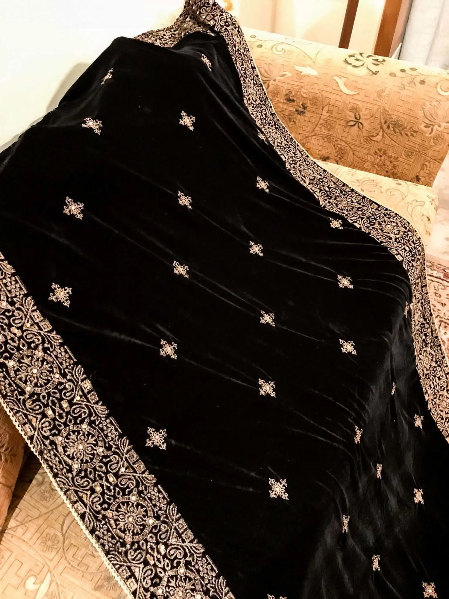 Luxurious velvet shawl adorned with gold tila embroidery, stone work and tassels, ideal for enhancing festive and formal attire.