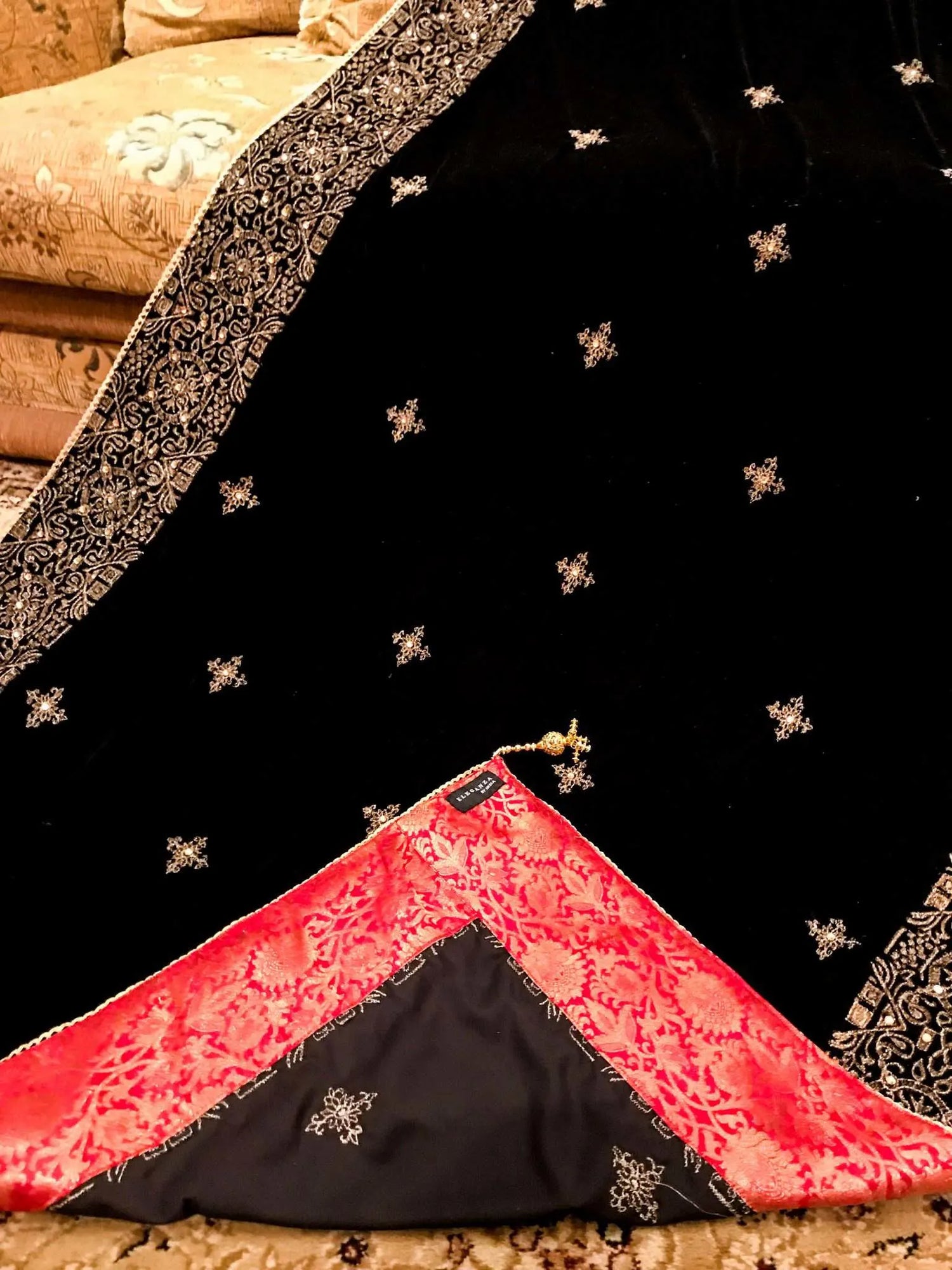Luxurious velvet shawl adorned with gold tila embroidery, stone work and tassels, ideal for enhancing festive and formal attire.
