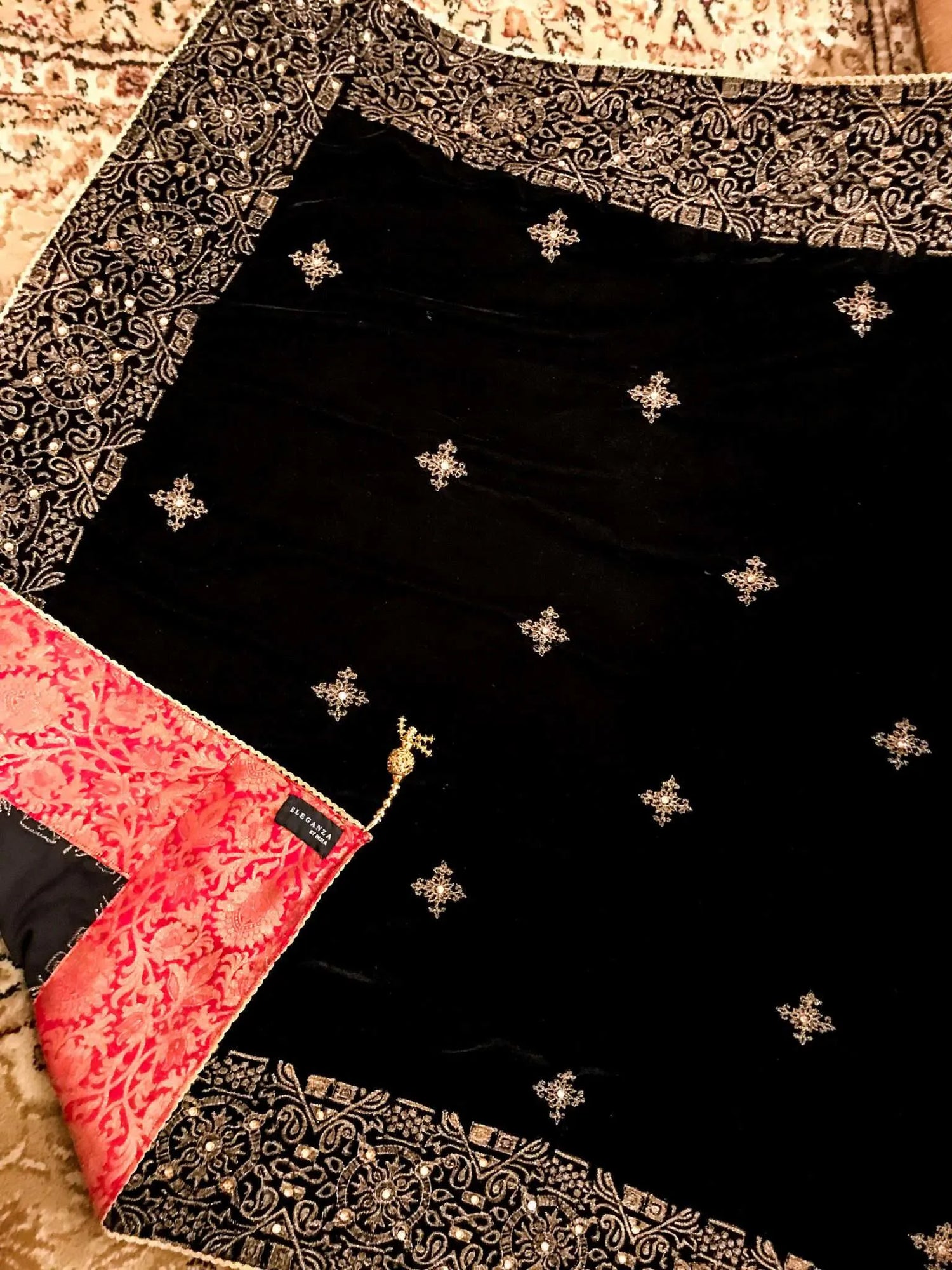 Luxurious velvet shawl adorned with gold tila embroidery, stone work and tassels, ideal for enhancing festive and formal attire.
