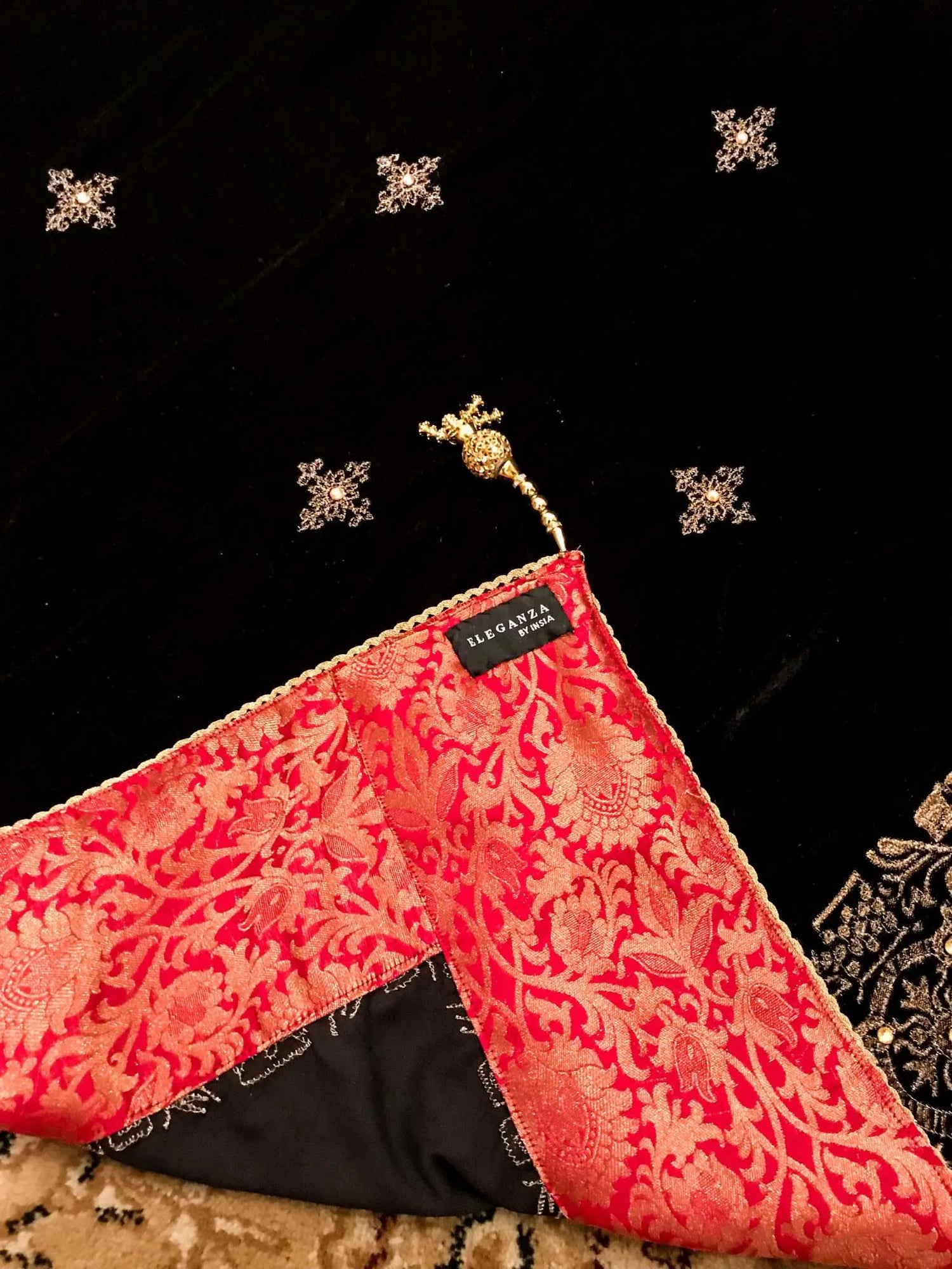 Luxurious velvet shawl adorned with gold tila embroidery, stone work and tassels, ideal for enhancing festive and formal attire.