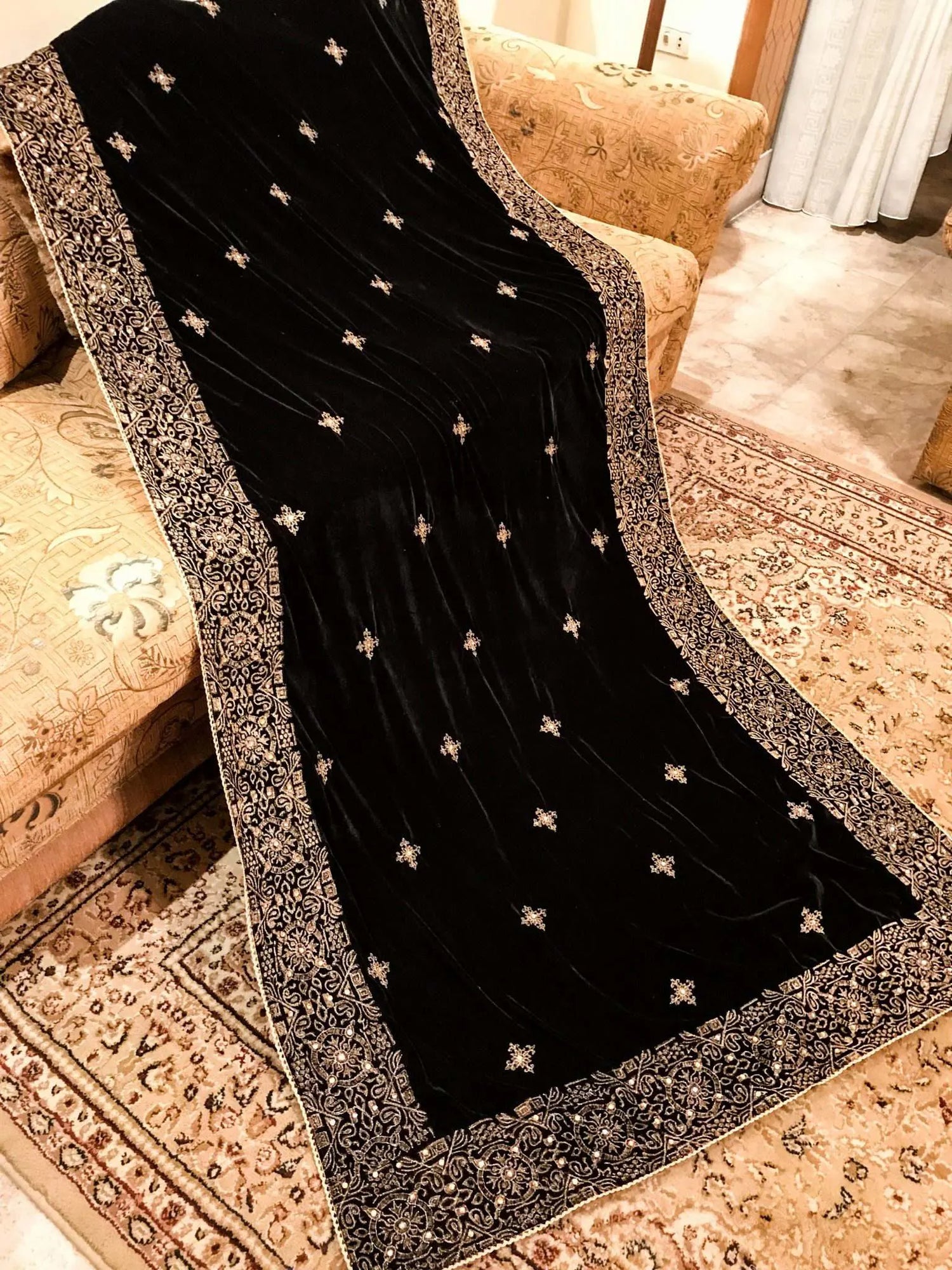 Luxurious velvet shawl adorned with gold tila embroidery, stone work and tassels, ideal for enhancing festive and formal attire.