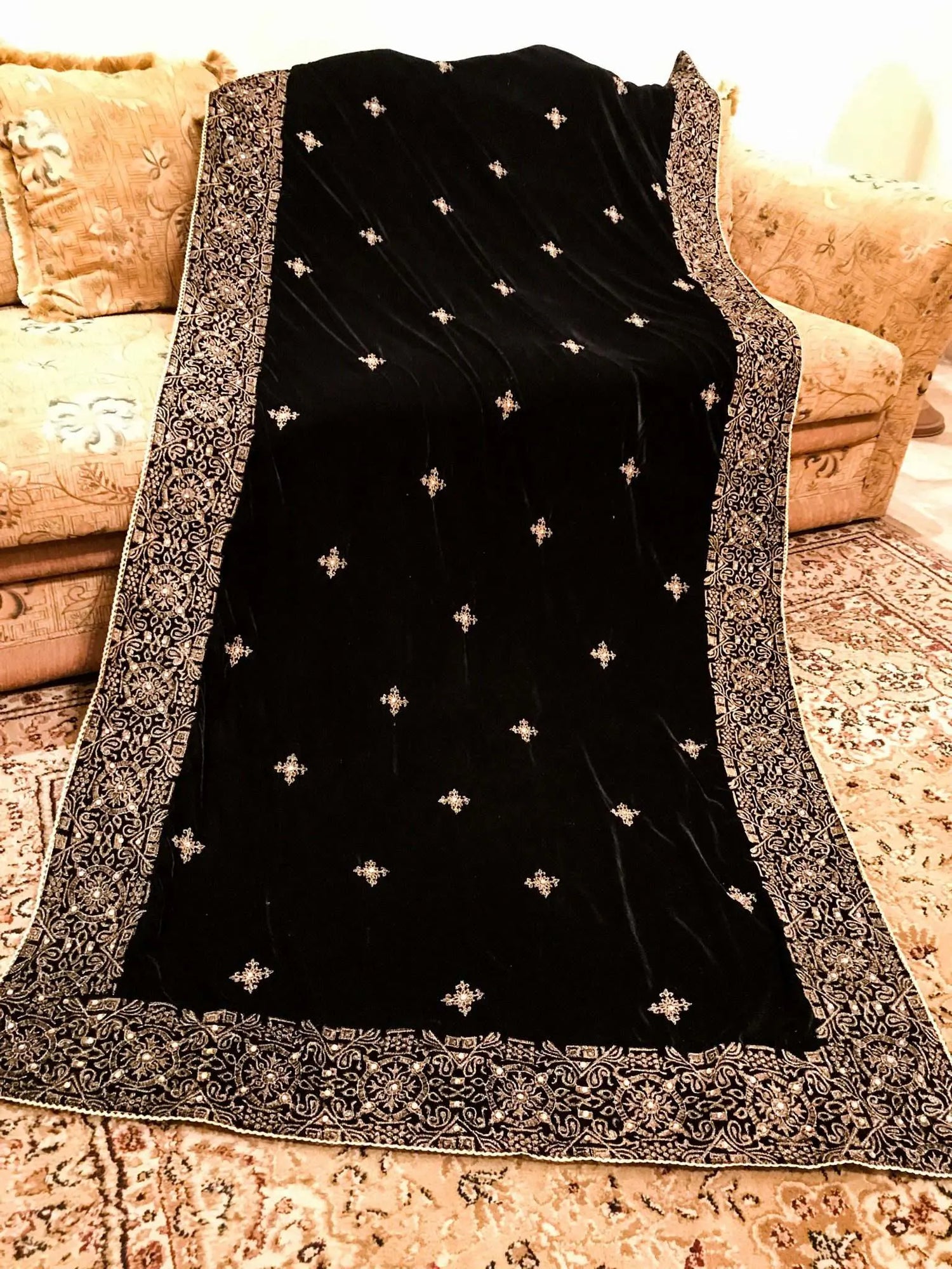 Luxurious velvet shawl adorned with gold tila embroidery, stone work and tassels, ideal for enhancing festive and formal attire.