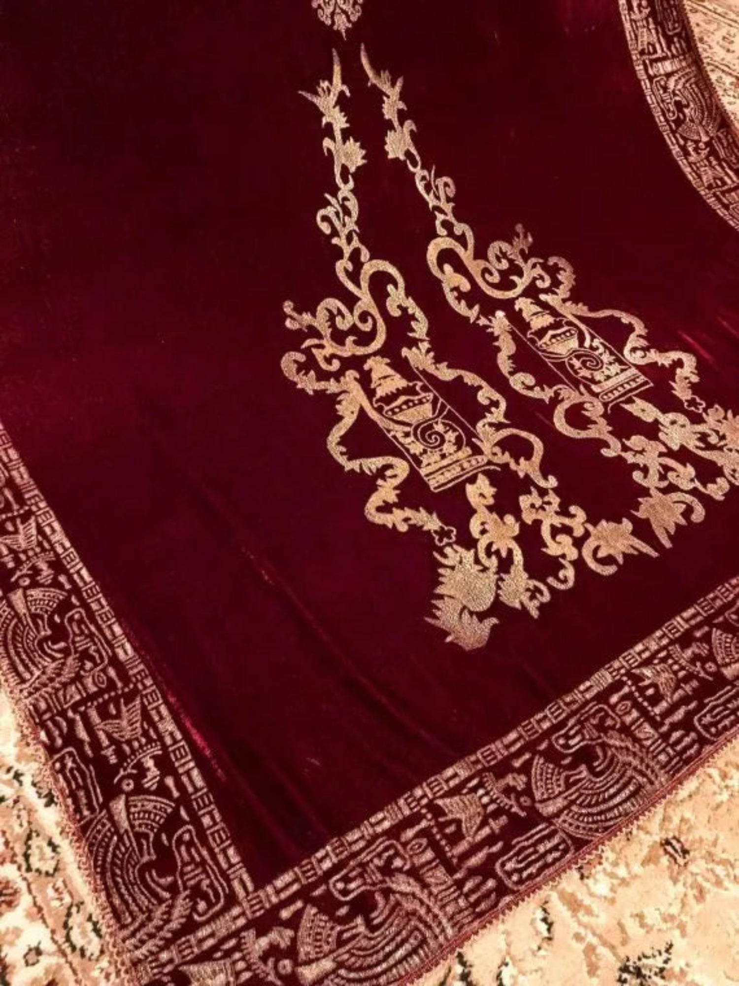 Luxurious velvet shawl with gold embroidery, featuring Mughal-inspired prints and a floral chata pattern, perfect for versatile styling and festive occasion.