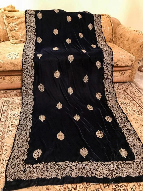 A luxurious black and gold velvet shawl with block-printed floral motifs adored with golden tila embroidery, highlighting rich texture and elegant design.