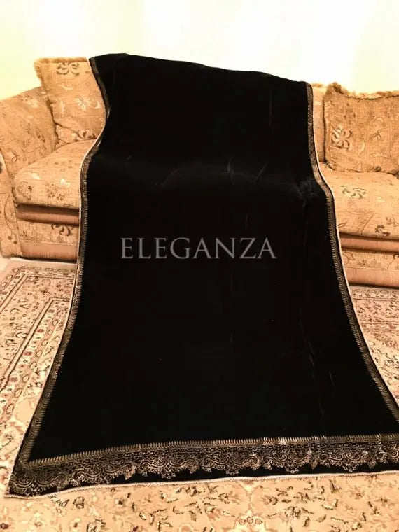 A velvet shawl featuring a block printed border and a shimmering golden thread, perfect for evening wear and formal gatherings.