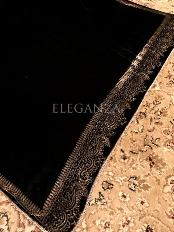 A velvet shawl featuring a block printed border and a shimmering golden thread, perfect for evening wear and formal gatherings.