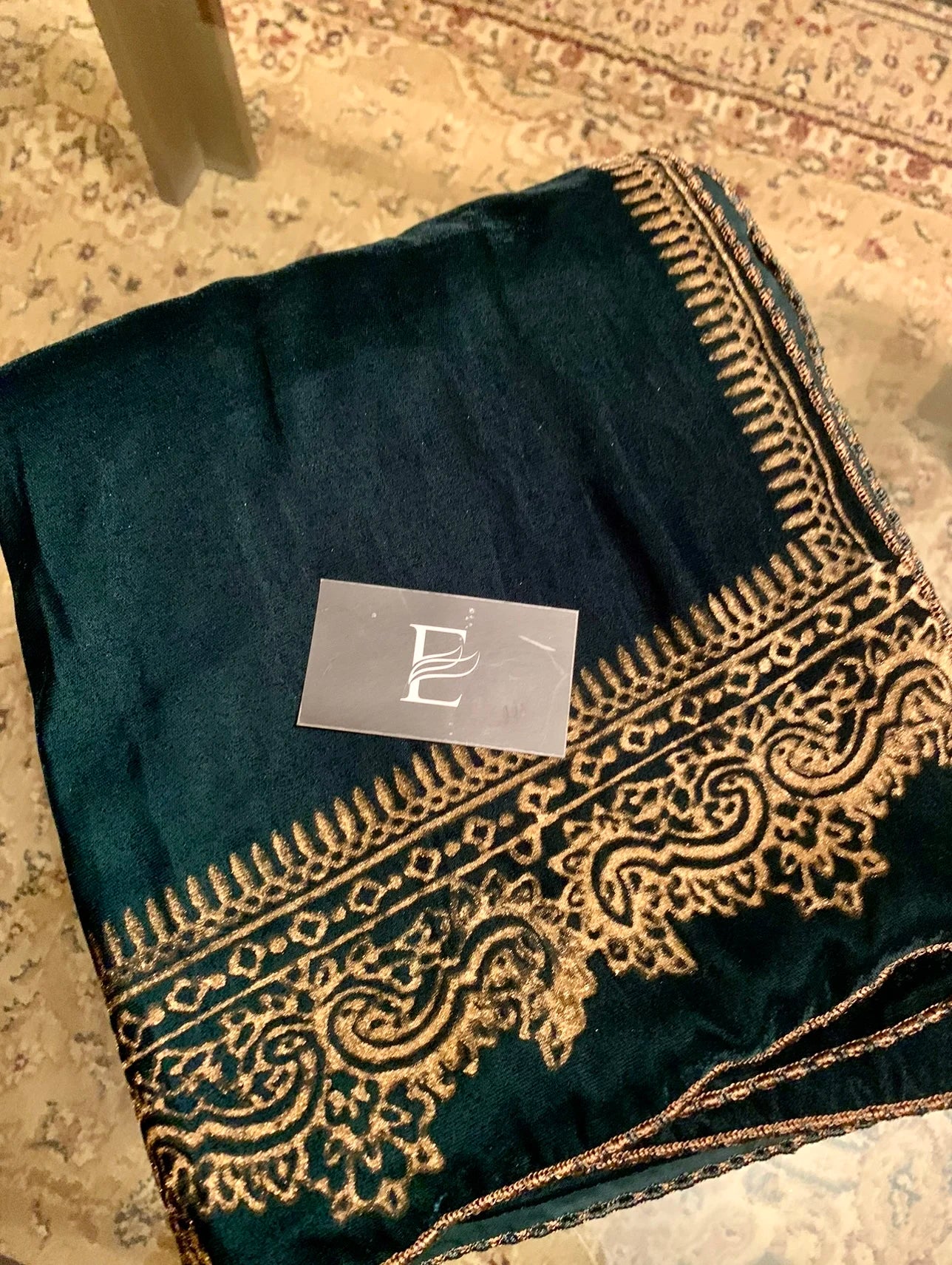 A velvet shawl featuring a block printed border and a shimmering golden thread, perfect for evening wear and formal gatherings.