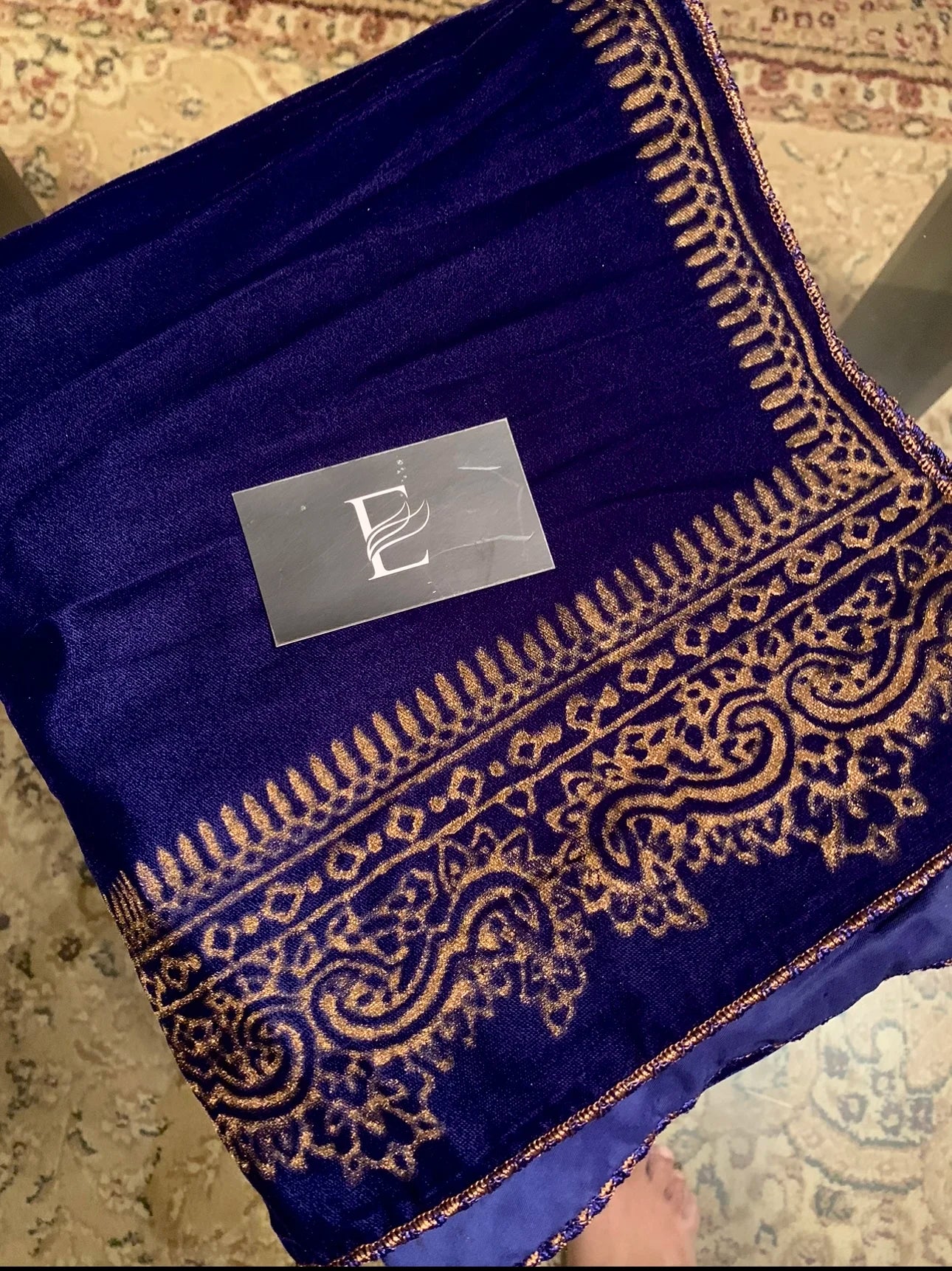 A velvet shawl featuring a block printed border and a shimmering golden thread, perfect for evening wear and formal gatherings.